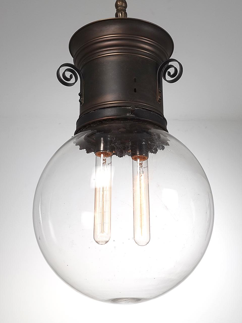 This is a simple and elegant pendent that started life as a Humphrey gas lamp. It is no reconfigured to electric using two standard E26 bulbs. The hand blown clear globe is a large one with a 12 inch diameter.