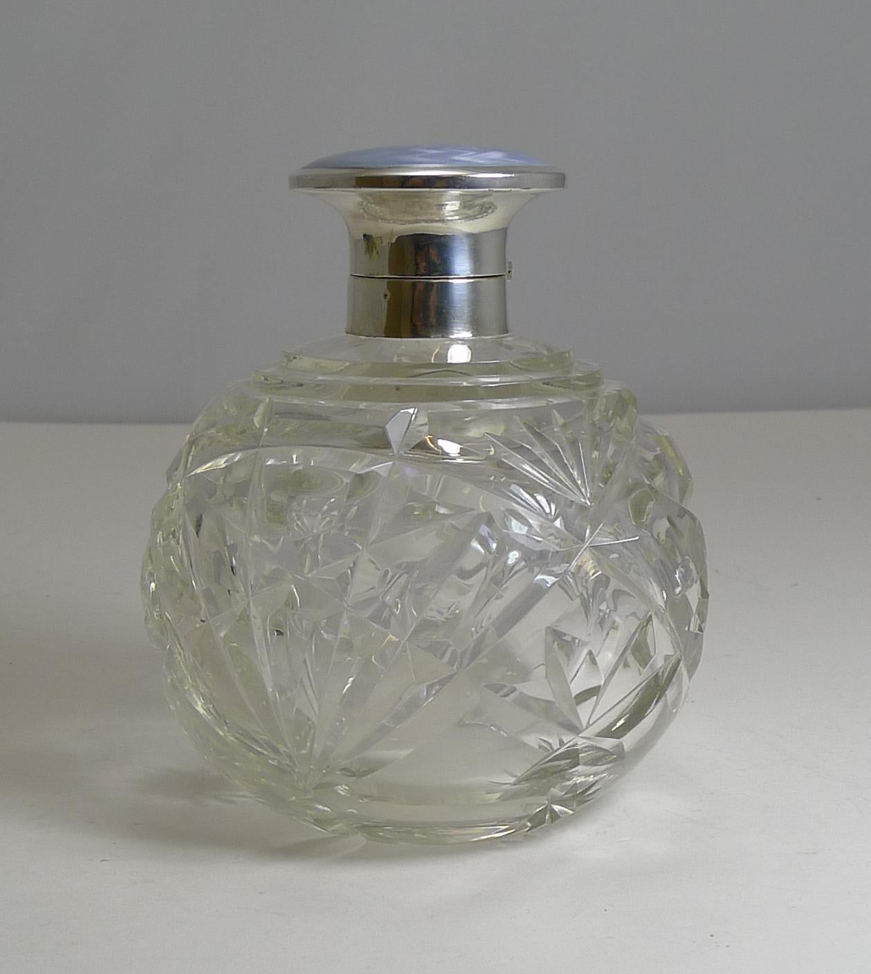 A wonderfully impressive sized perfume or scent bottle created from a hefty piece of English crystal beautifully handcut. The collar and hinged lid is made from English sterling silver fully hallmarked Birmingham 1918. The makers initials are also