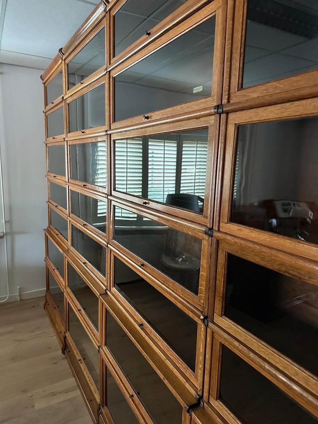 Grande e imponente libreria Globe Wernicke in rovere chiaro. In perfette condizioni. L'armadio è composto da 28 parti impilabili. Anche i cassetti nei piedi. Può essere costruito in diverse configurazioni. 

Origine: Inghilterra
Periodo: ca.