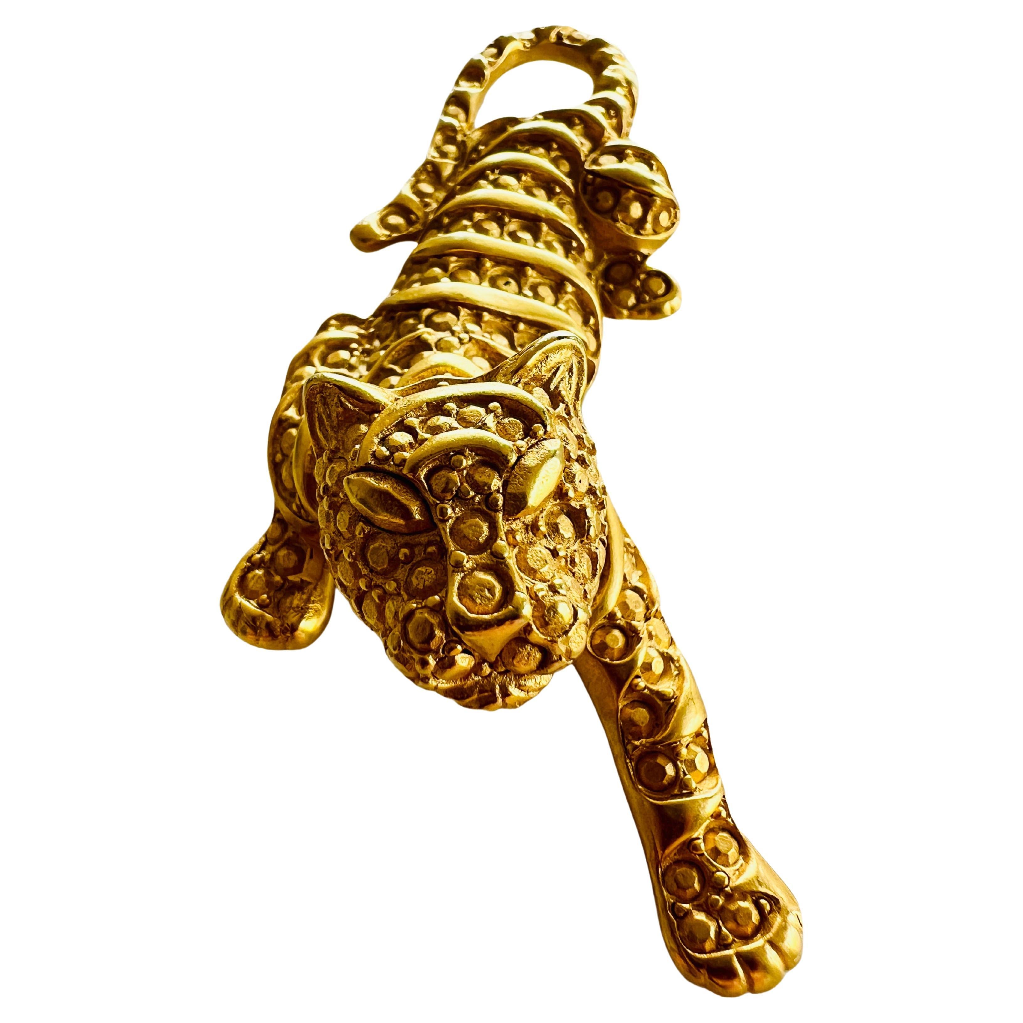 This striking large gold tiger brooch is a statement piece in its own right. It boasts an exceptional, textured, three-dimensional metal design that cleverly mimics the appearance of rhinestones. This approach achieves a refined elegance, offering a