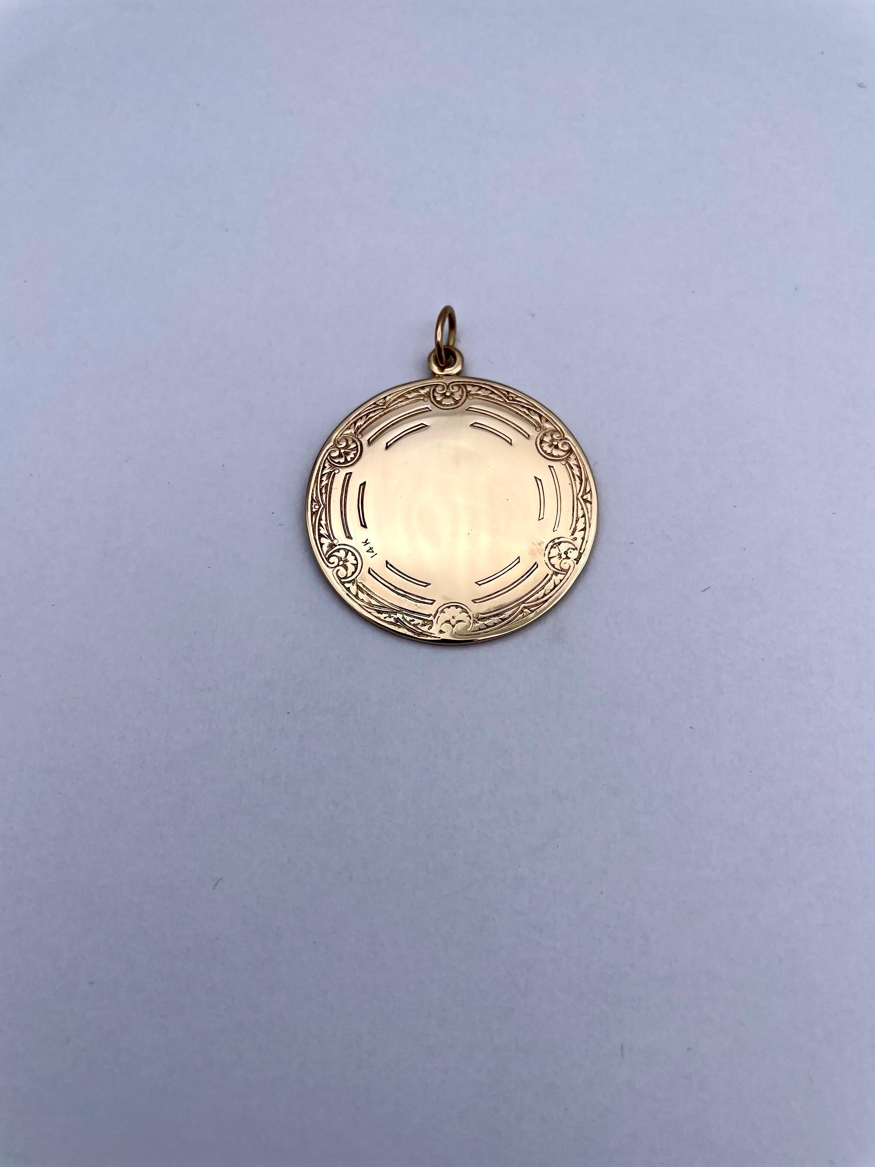 Striking large medallion/pendant/charm.  Depicting a deeply engraved fisherman, wearing a hat, with a fishing pole and a fish.  He is standing in the water, with hills and mountains in the distance.  The reverse side has a finely engraved border,
