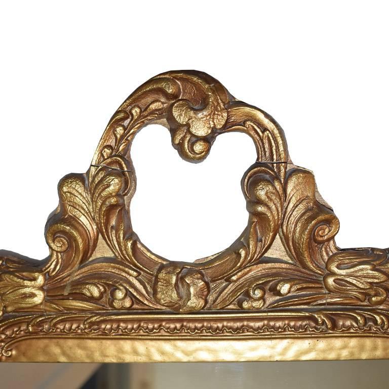 Large rectangular giltwood mirror. In a wide rectangular shape, with hand-carved details on top. Wear is consistent with age. Gorgeous over a mantel, or as an addition to a wall of mirrors.