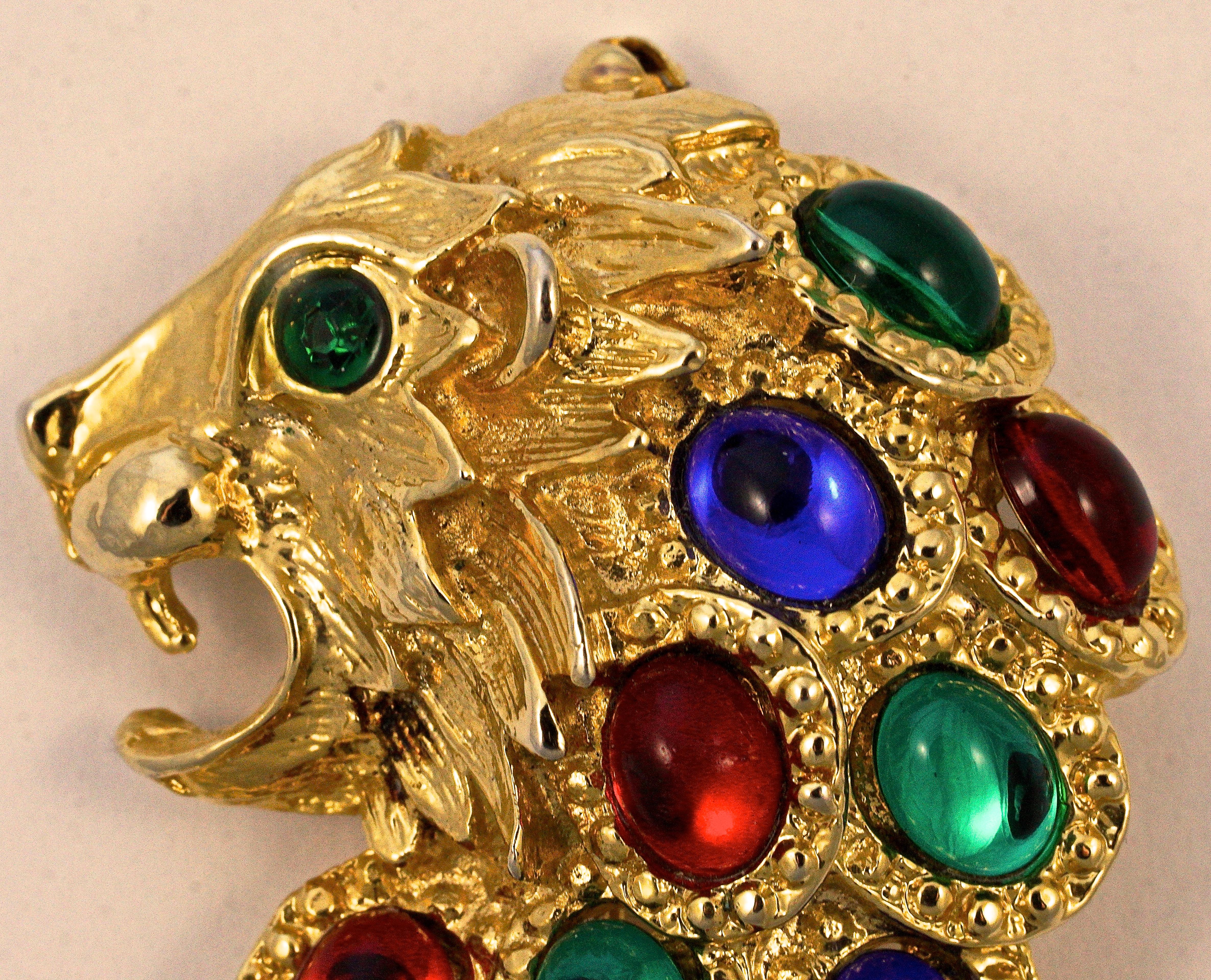Vintage gold plated and textured lion brooch with green eyes, embellished with blue, red and green oval stones. Measuring length 7.5cm / 3 inches by maximum 5.3cm / 2.08 inches.

Large and beautiful, this lion statement brooch is sure to attract