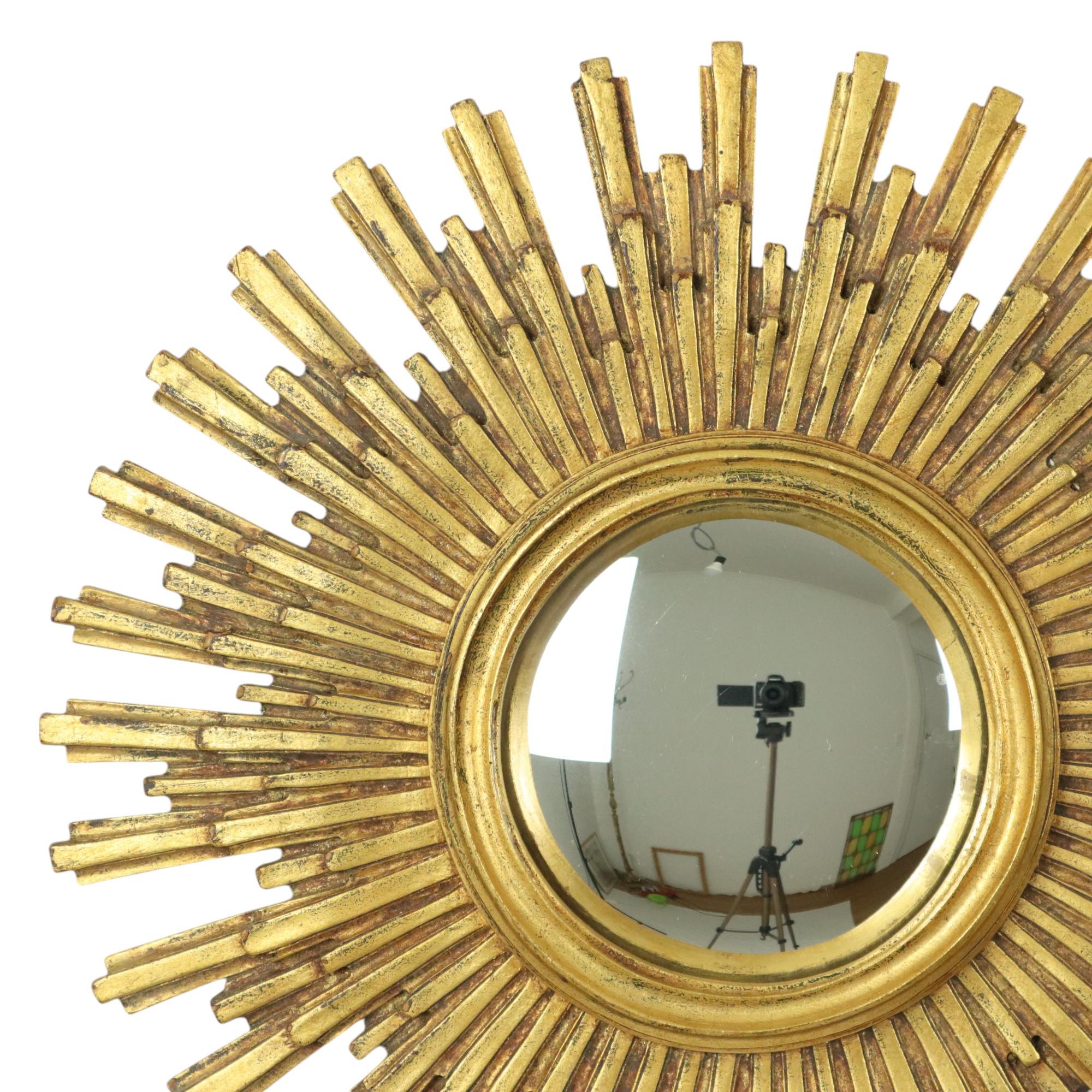 Large gold leaf gilded sun mirror, sunburst mirror made of resin, with a convex mirror, circa mid 20th century, numbered on the back.

Beautiful object with a very nice age patina, the gold leaf has discoloured slightly which makes the rays stand