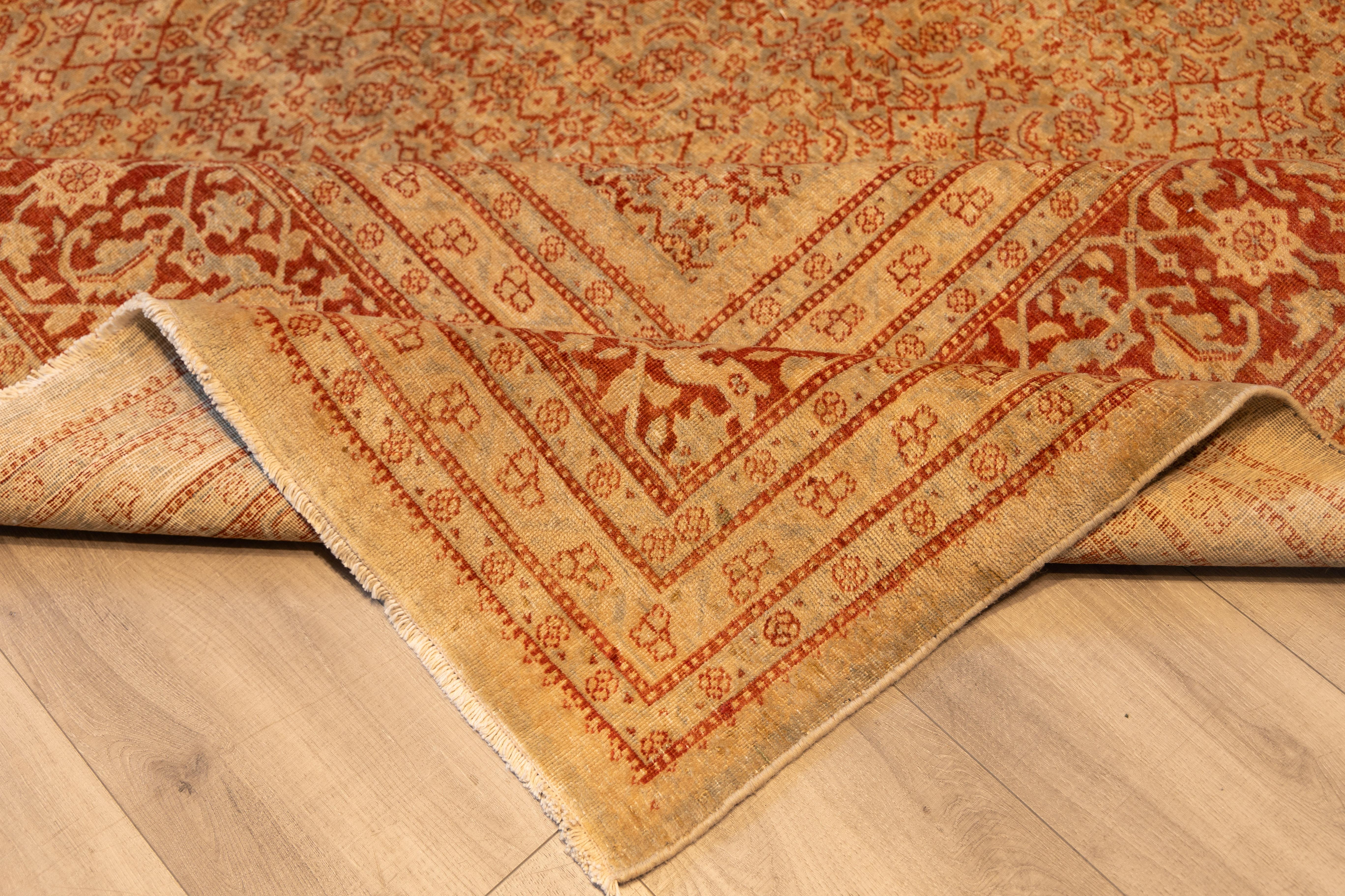 A finely detailed carpet featuring an allover design composed of densely interlaced floral motifs arranged in a precise, repeating lattice. The pattern is executed in a restrained palette of Abrash red, pale gold, and sand, creating a tone-on-tone