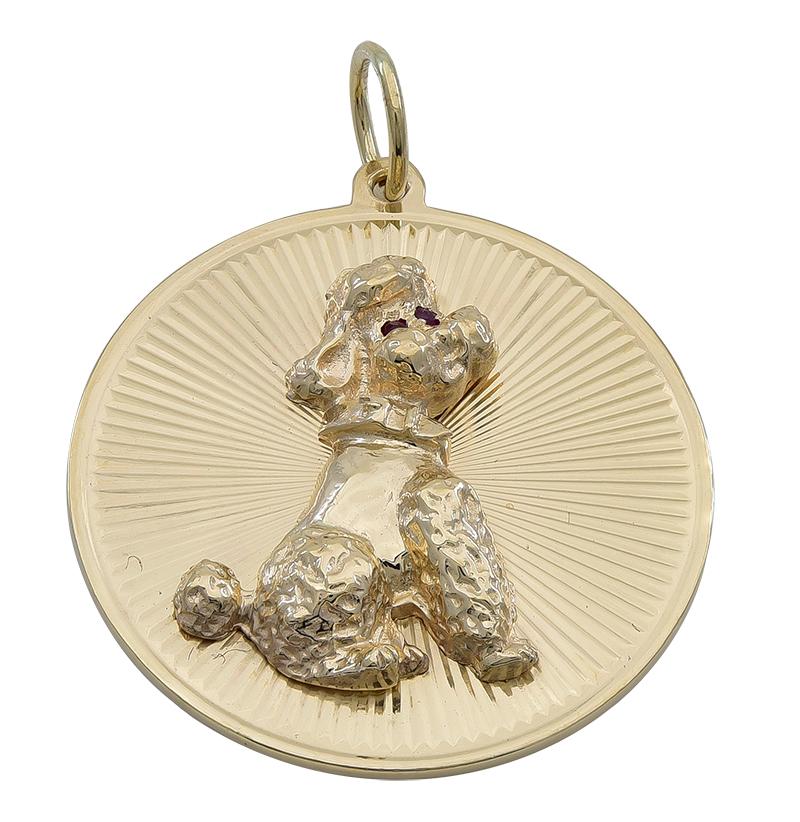 Round disc, with radiating line pattern.  Made and signed by TIFFANY & CO.  Applied in the center is a  wistful poodle. with faceted ruby eyes.  Solid gauge 14K yellow gold.  1 1/4