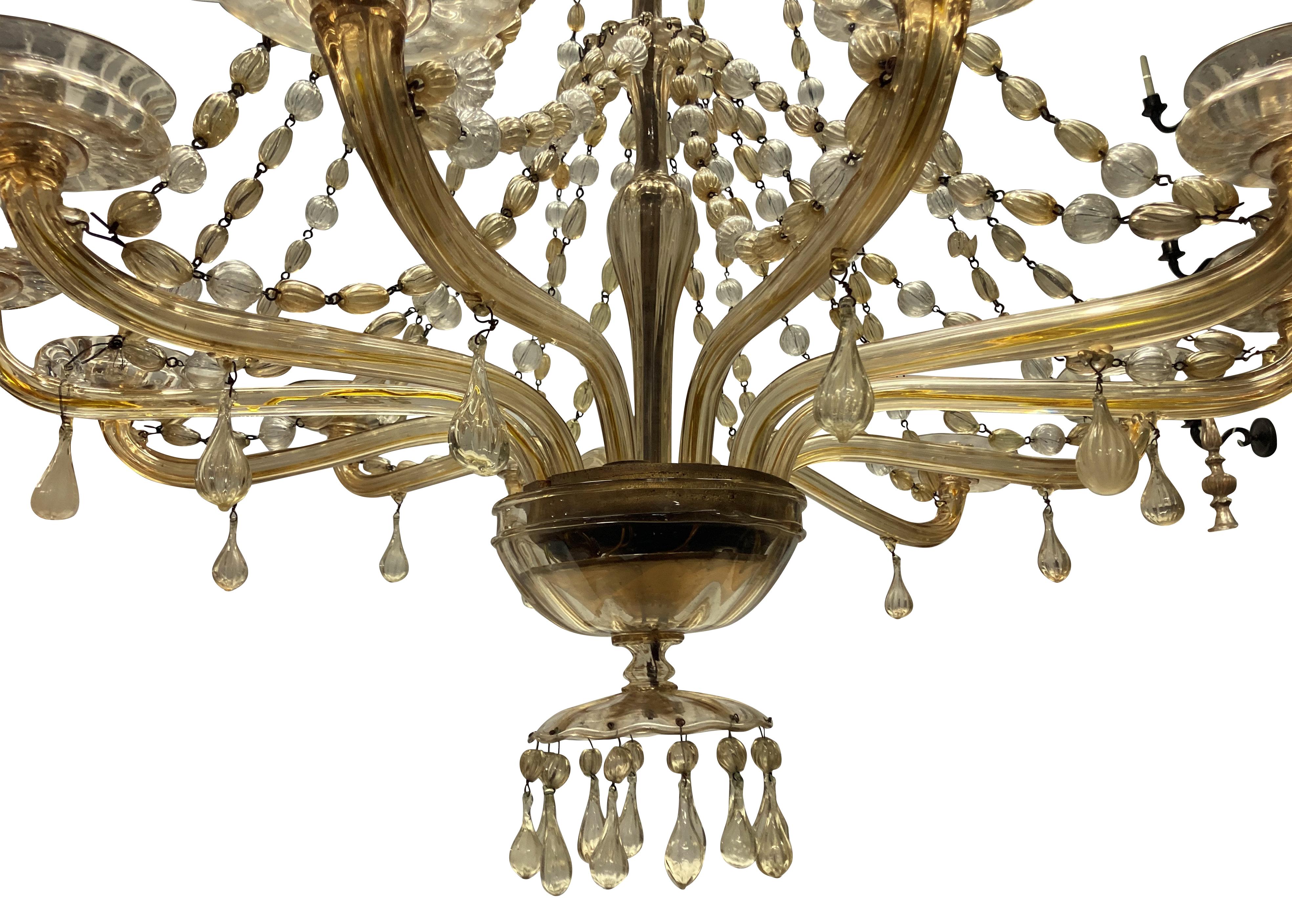 A large Italian hand blown gold tinted glass chandelier by Fratelli Toso. Of twelve arms, hung throughout with clear and gold tinted baubles. Two pans are later replacements, otherwise entirely intact. Signed.