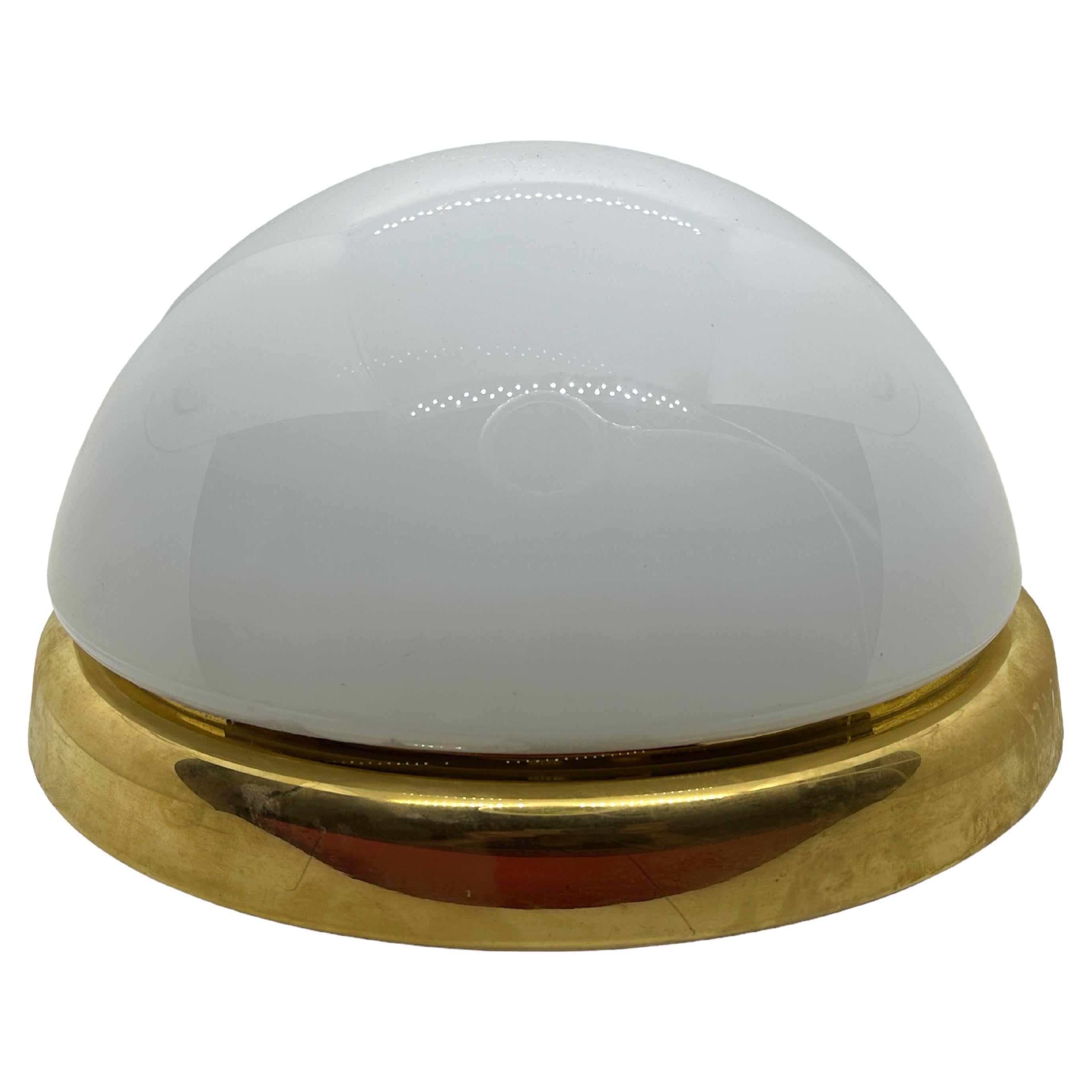 A beautiful flush mount by German manufacturer Glashuette Limburg. The largeglass element is supported by a polished brass plate with a two light source. Beautiful milk glass on a metal fixture. The Fixture requires two European E27 / 110 Volt