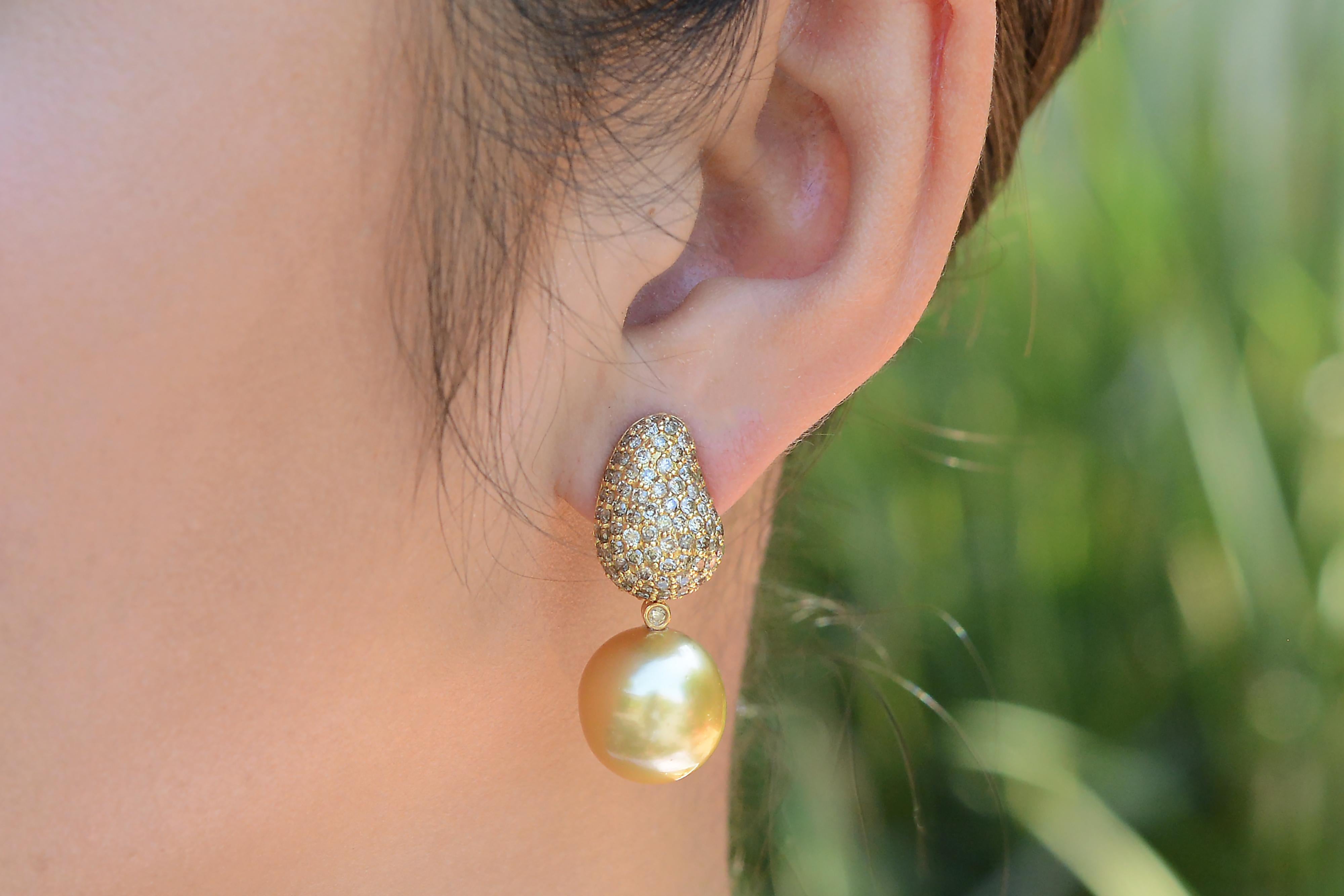 Dangling beneath are a pair of perfectly sun-kissed natural colored golden South Sea pearls suspended by a single bezel set diamond. Their depth of color, luster, size and complexion are top-notch, AAA grade. These convertible drop earrings are a