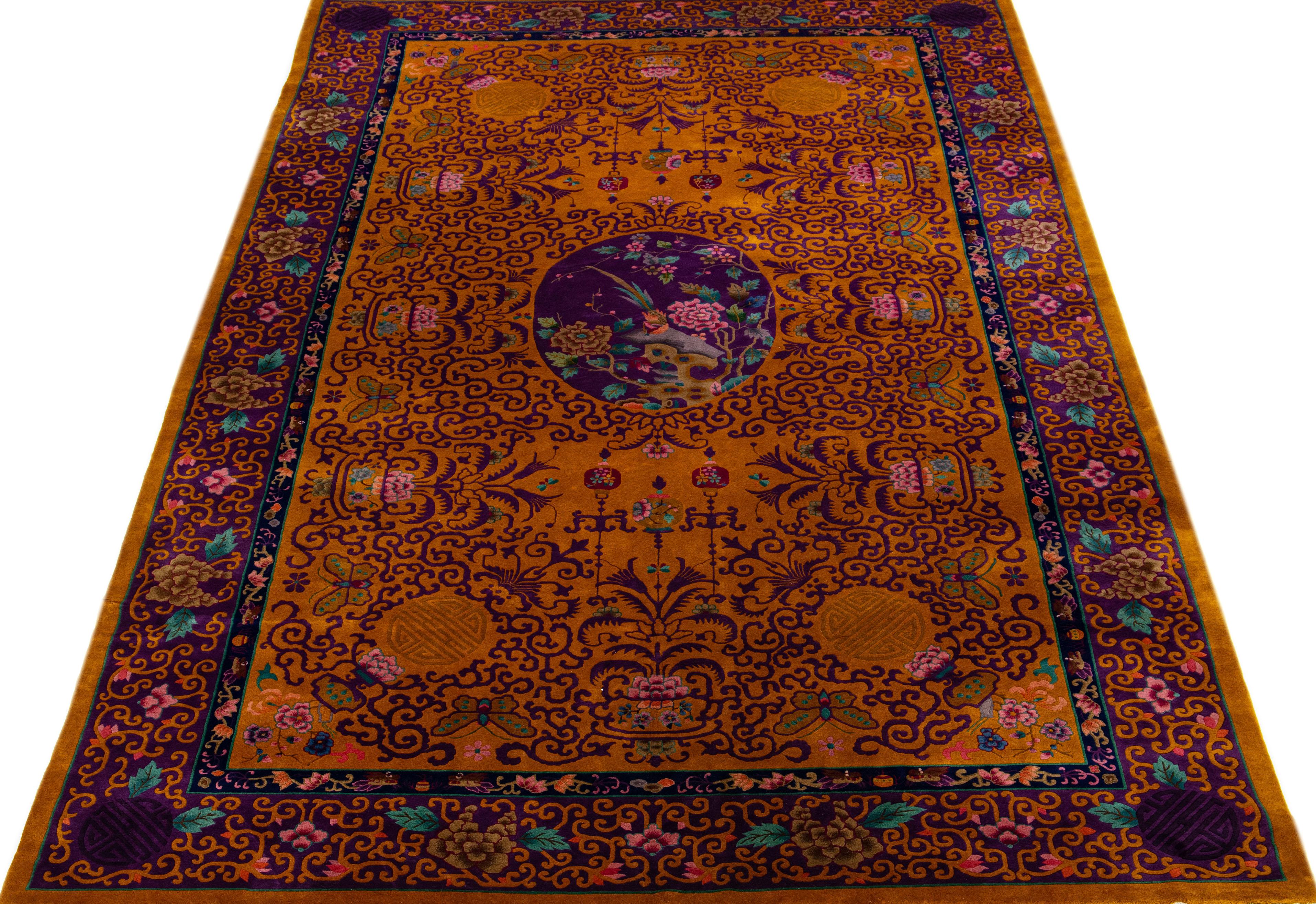 A beautiful oversize antique Chinese Art Deco wool rug with a goldenrod field. This hand knotted Rug has a frame of purple and multi-color accents in an all-over Chinese botanical design.

This rug measures 11' 9