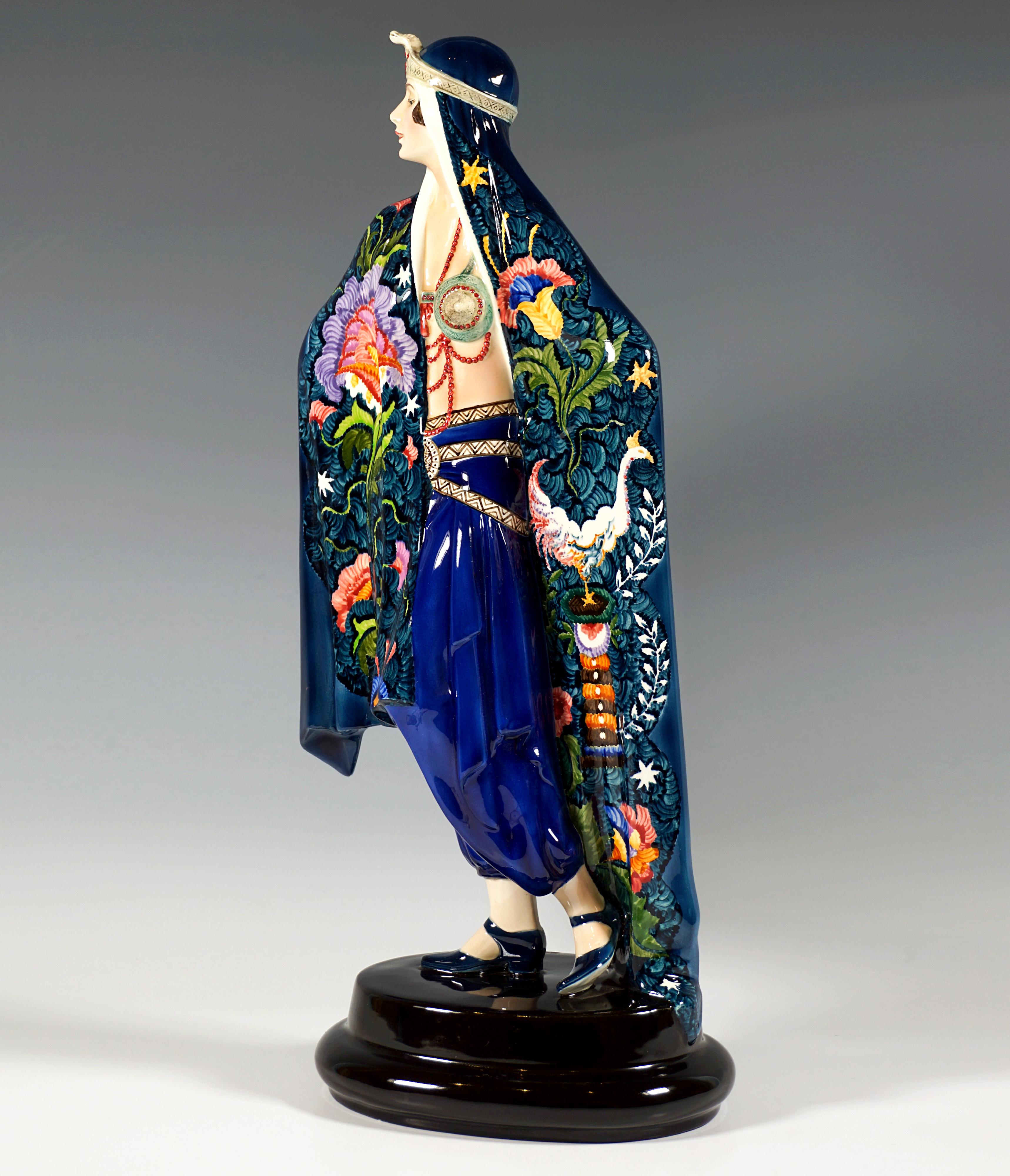 Exceptional Goldscheider Art Deco ceramic figure of the 1920's:
Depiction of a standing lady proudly looking to the side in oriental garb, wrapped in a large blue-green cloth reaching to the ground, decorated on the front with stylized floral and