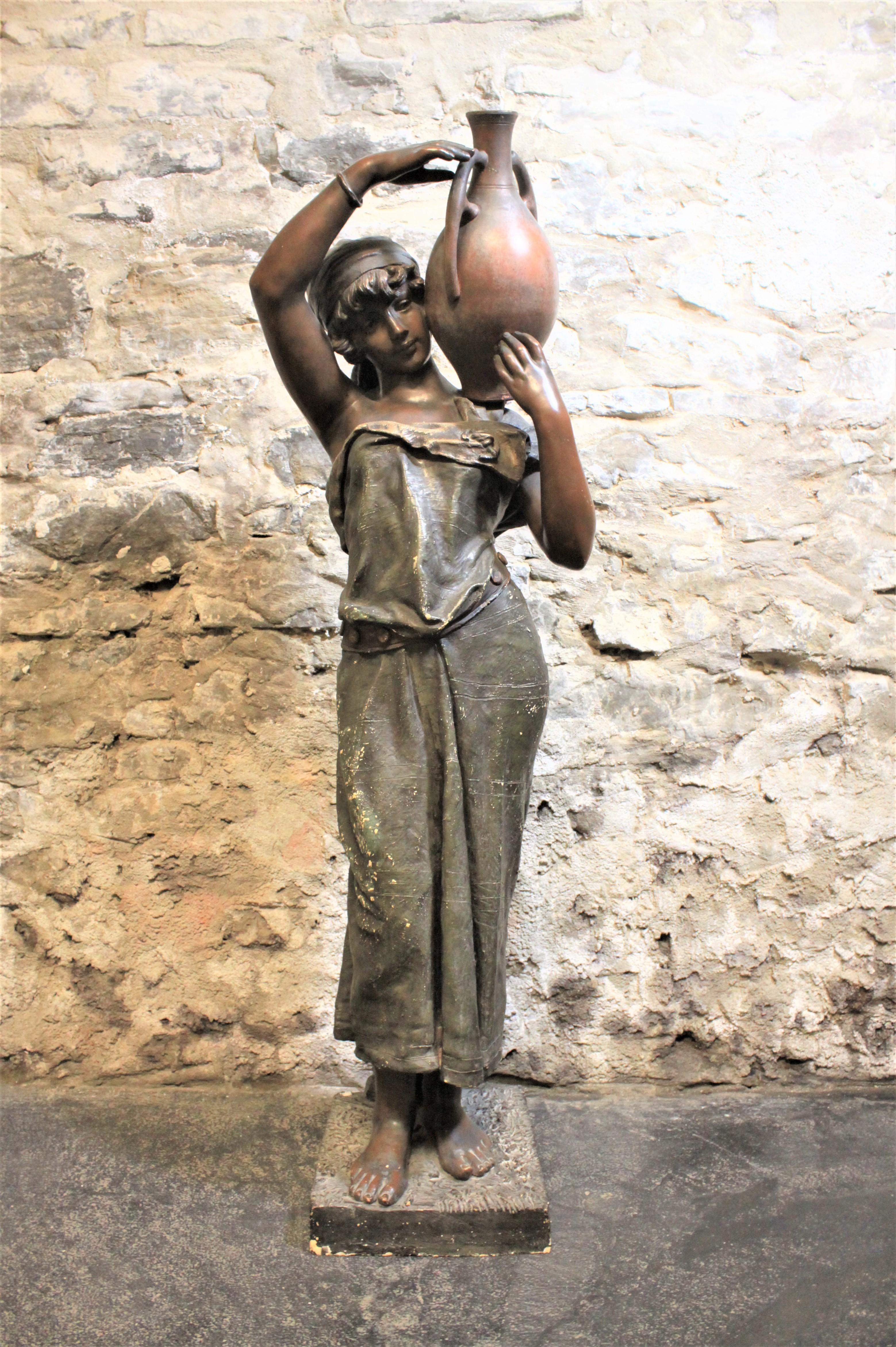 Cette grande sculpture Art nouveau signée Goldsheider est réalisée en terre cuite patinée et date d'environ 1900-1920. La statue est réalisée dans un style néoclassique et représente une femme portant de l'eau, vêtue d'une robe fluide.
