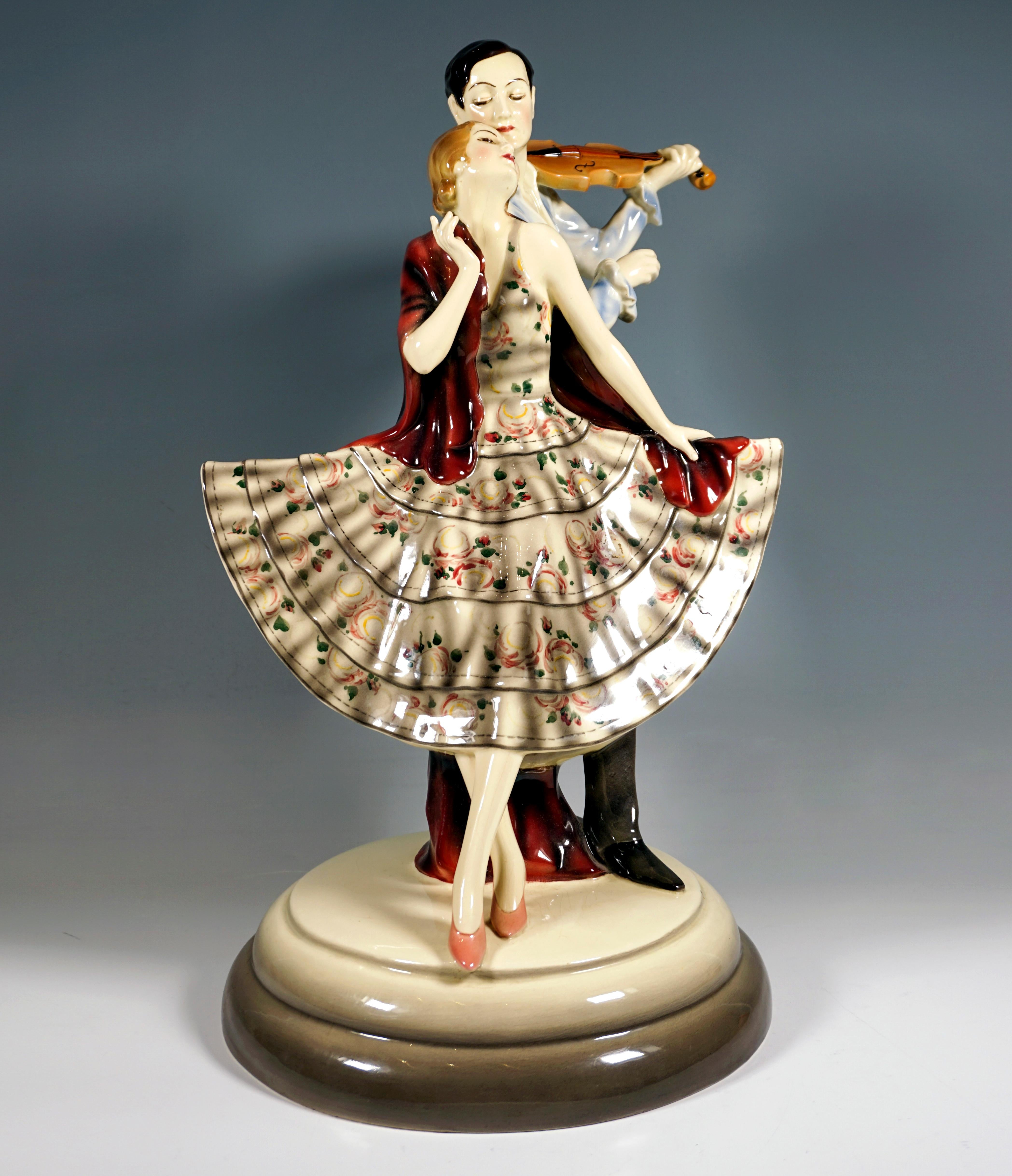 Rare Art Déco Goldscheider Figure Group Of The 1930s:
Gallant couple: dancer in a fan-like flared dress with flounces and floral decoration with her upper body and crossed legs leaning on the right side of the violinist standing behind her in a