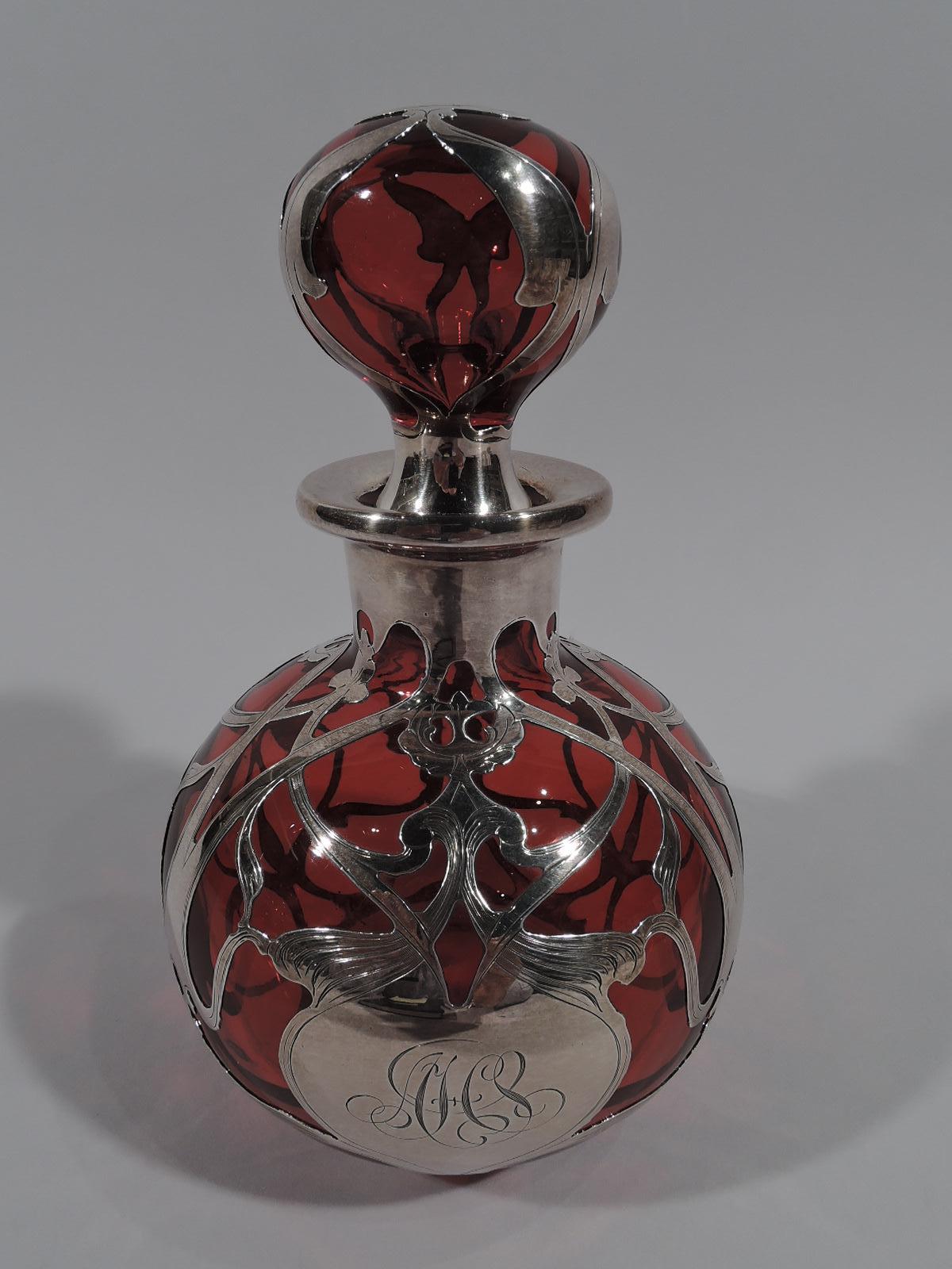 Large turn-of-the-century Art Nouveau glass perfume with engraved silver overlay. Made by Gorham in Providence. Globular with everted rim. Ball stopper with short plug. Loose and interlaced silver scrollwork with flower heads in open and symmetrical
