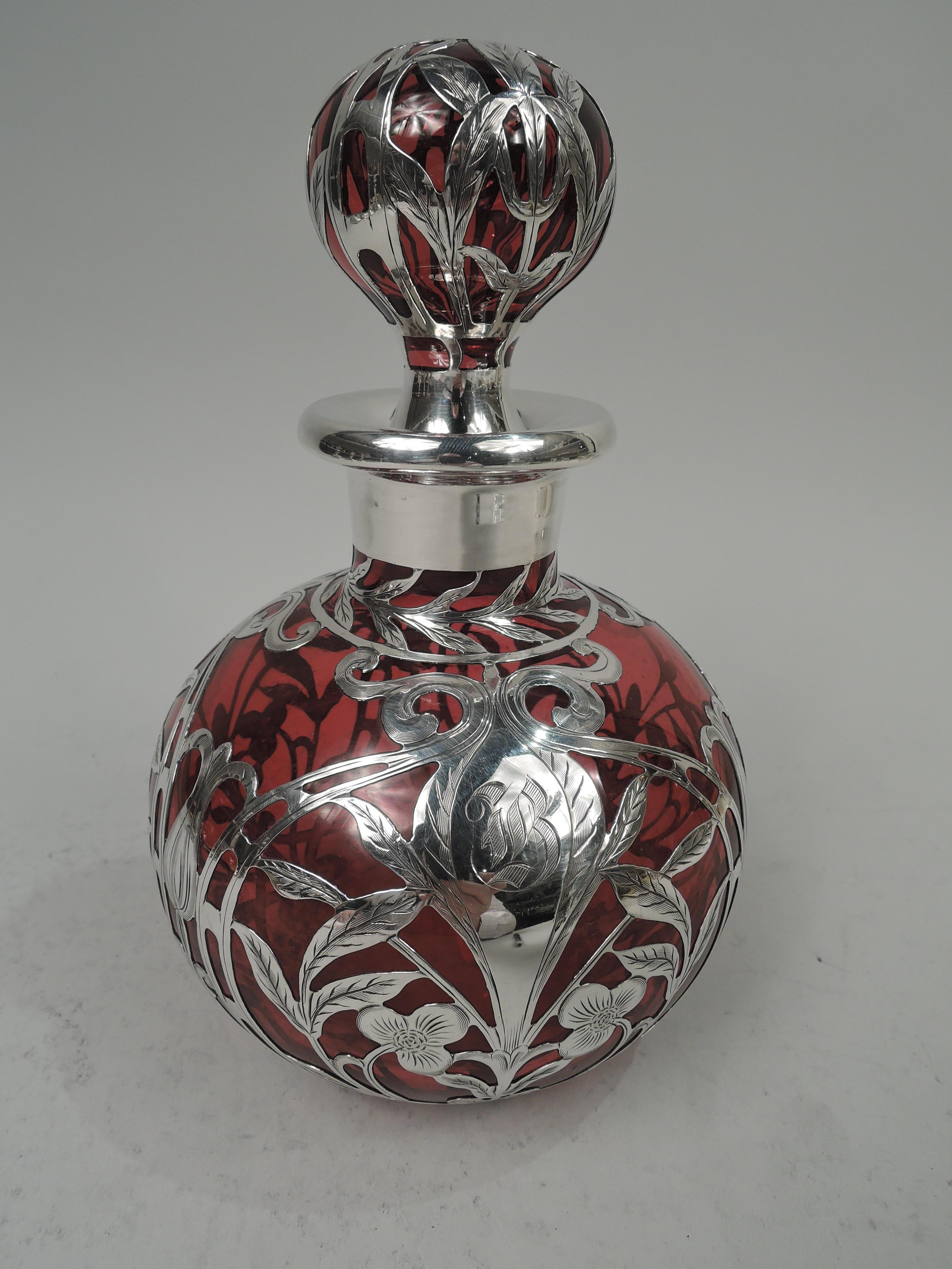 Large Art Nouveau glass cologne with engraved silver overlay. Made by Gorham in Providence, ca 1910. Globular with short neck and everted rim in silver collar. Ball stopper. Symmetrical overlay in fluid whiplash tendrils and stylized leaves and