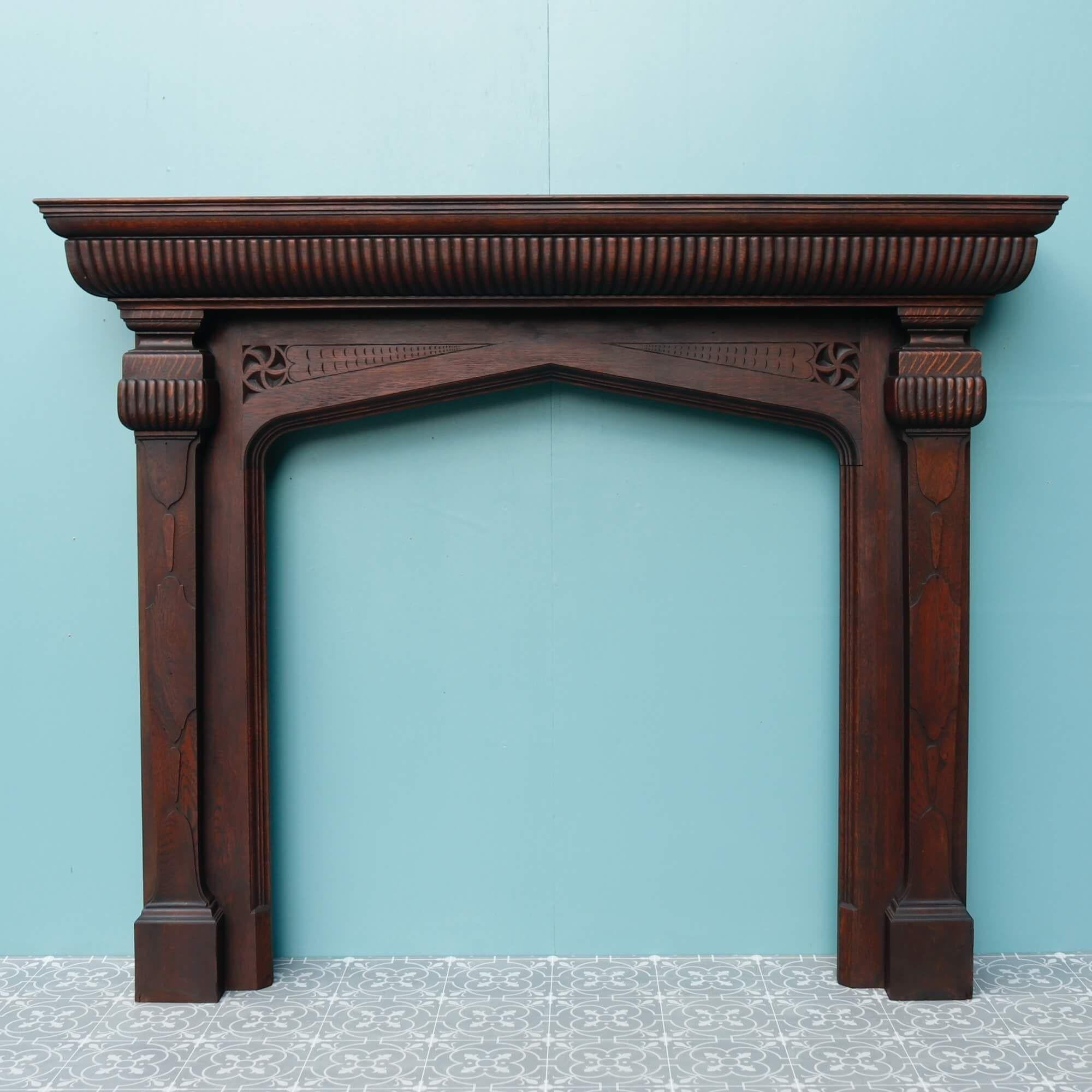A deep, large scale English solid oak antique fireplace dating from the 1880s. Re-finished, this spectacular fireplace has a rich patina throughout that looks impressive in a variety of period settings. The craftsmanship is a blend of Tudor, Gothic