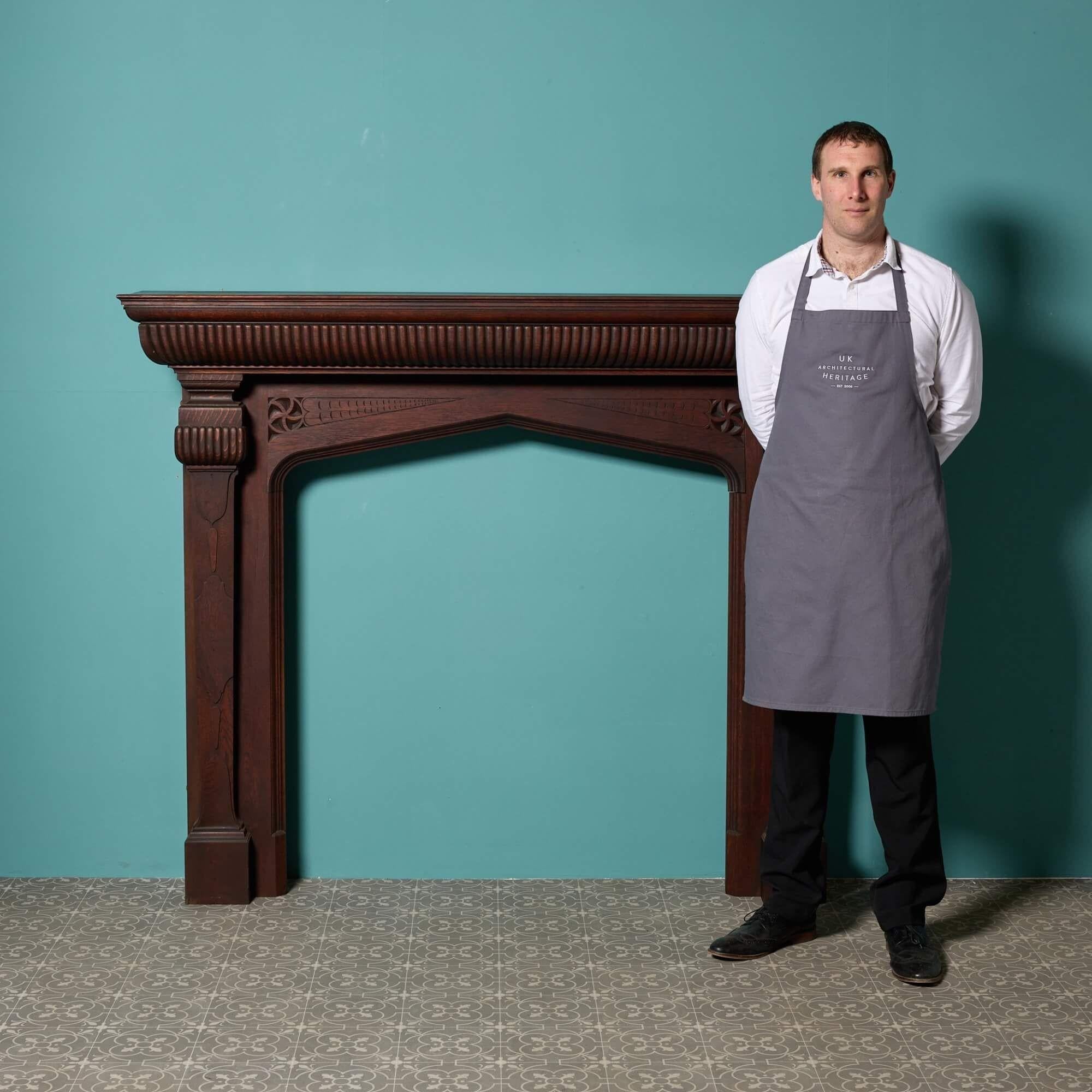 A deep, large scale English solid oak antique fireplace dating from the 1880s. Re-finished, this spectacular fireplace has a rich patina throughout that looks impressive in a variety of period settings. The craftsmanship is a blend of Tudor, Gothic