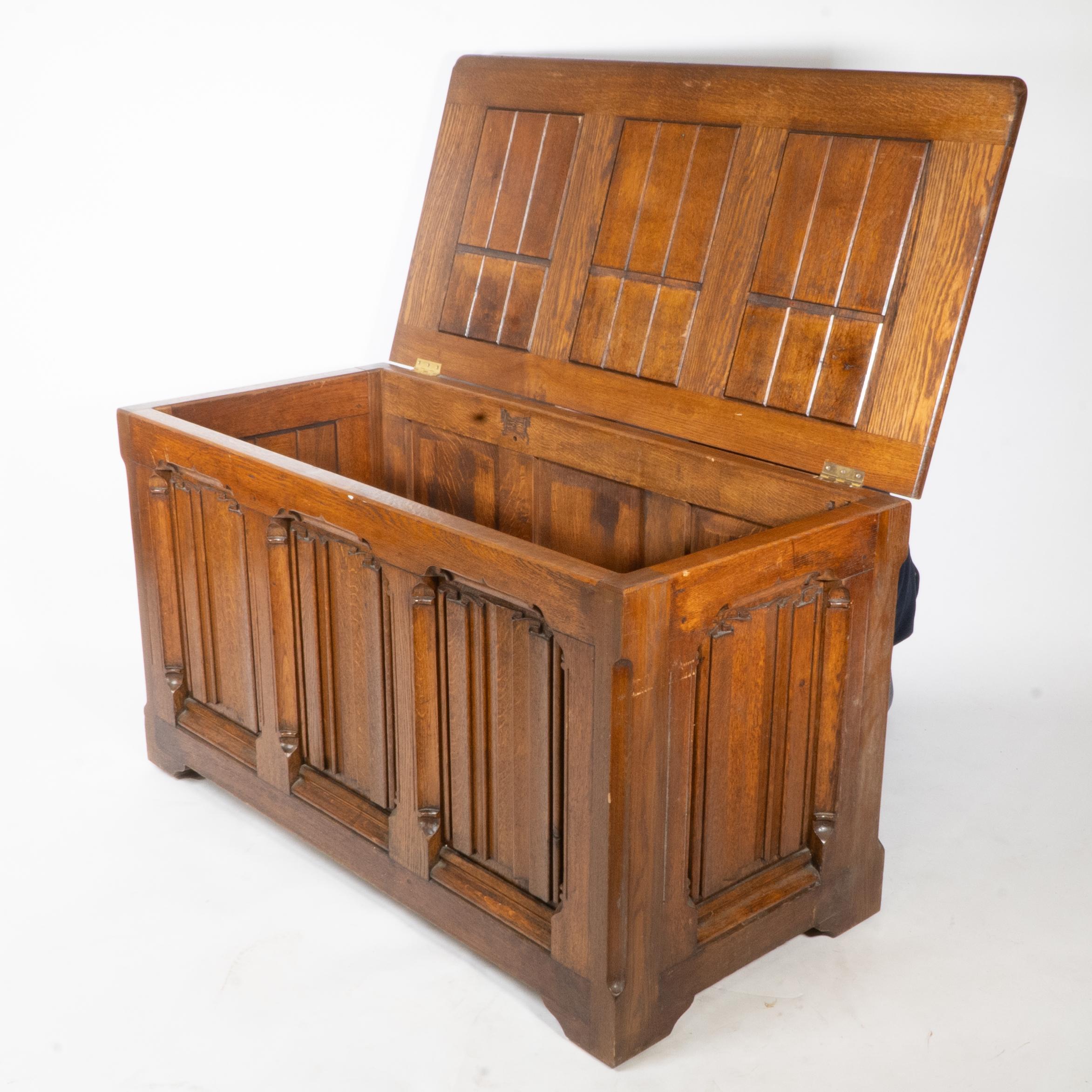 A large Gothic Revival oak blanket chest or linen trunk with deeply carved linenfold decoration to the lift up lid and to all four sides. Each linenfold panel is framed with half concave molded details with birds beak ends to each of the four