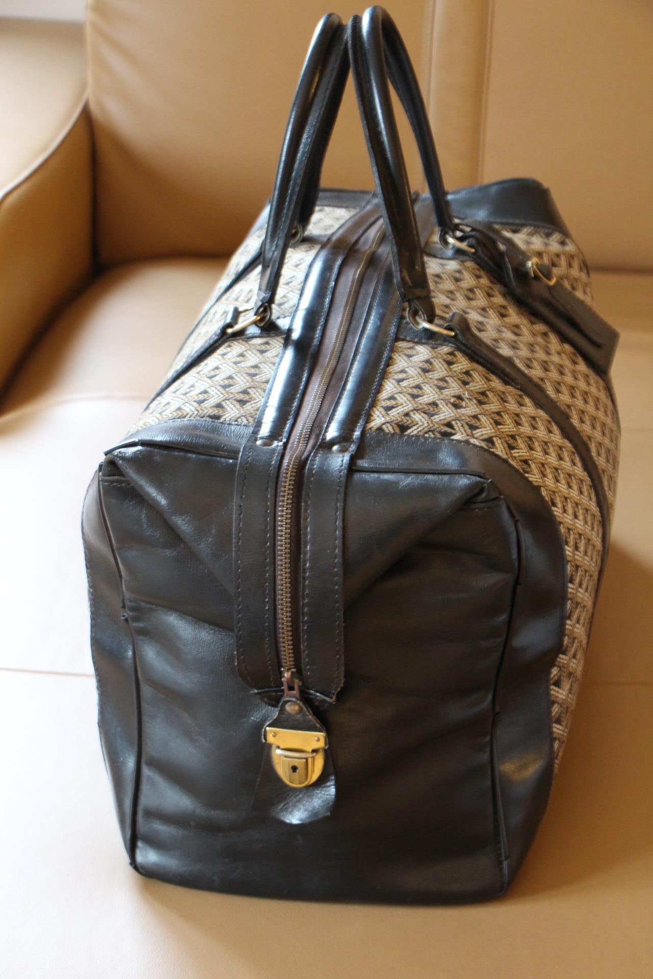 Este bonito bolso Goyard tiene el famoso tejido de lona con galones de Goyard, así como muchas piezas de piel de color negro. Tiene 2 cómodas asas de piel y se abre por la parte superior gracias a su cremallera que funciona muy suavemente.
Aún