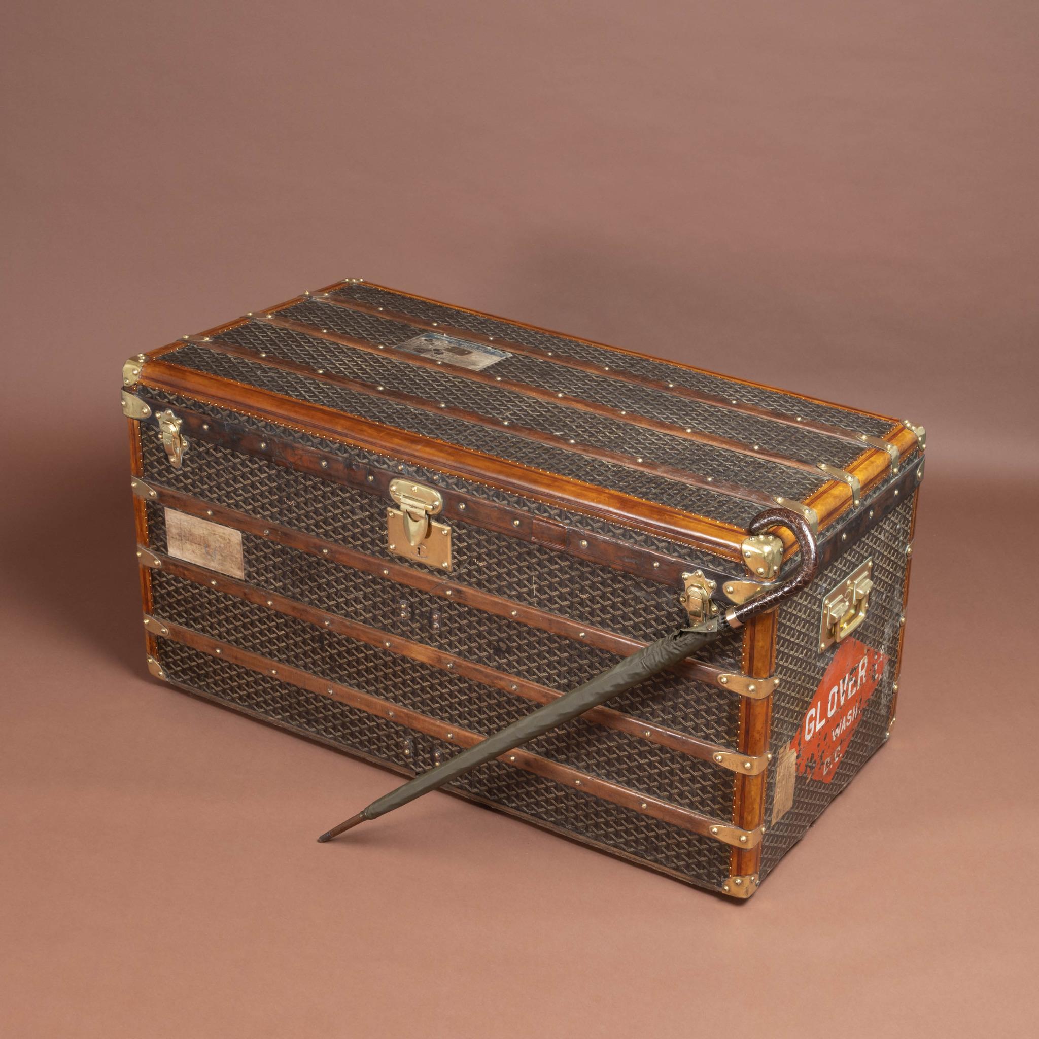 Large steamer trunk by Goyard in their signature 'Goyardine' chevron pattern canvas covering with polished brass lock, catches & handles; circa 1910. 

All of the leather trim on the trunk, except the front and one of the sides of the band that runs