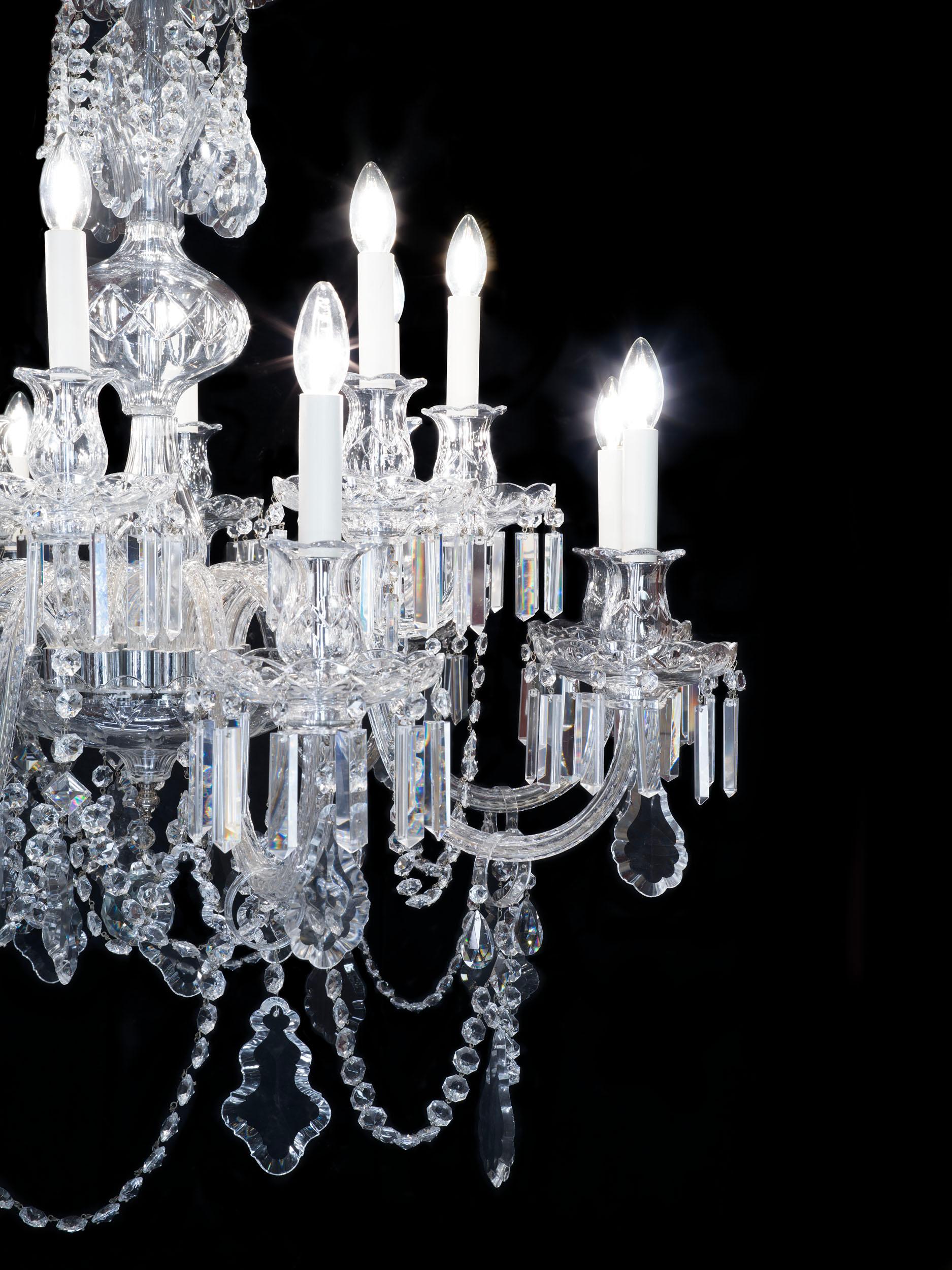 A very large and imposing English crystal chandelier of exceptional quality in the Victorian style. The 16 branch chandelier is truly a statement piece, with a long baluster stem from which emanates two tiers of swan neck arms, profusely hung with