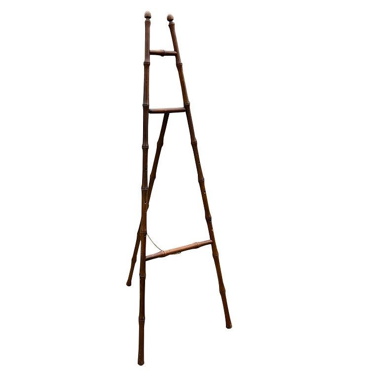 A rare monumental faux bamboo French floor display easel. This tall stand is great for displaying large-scale paintings. It is created from wood and turned to resemble bamboo stalks. It is stained in a rich brown throughout. It has three legs, two