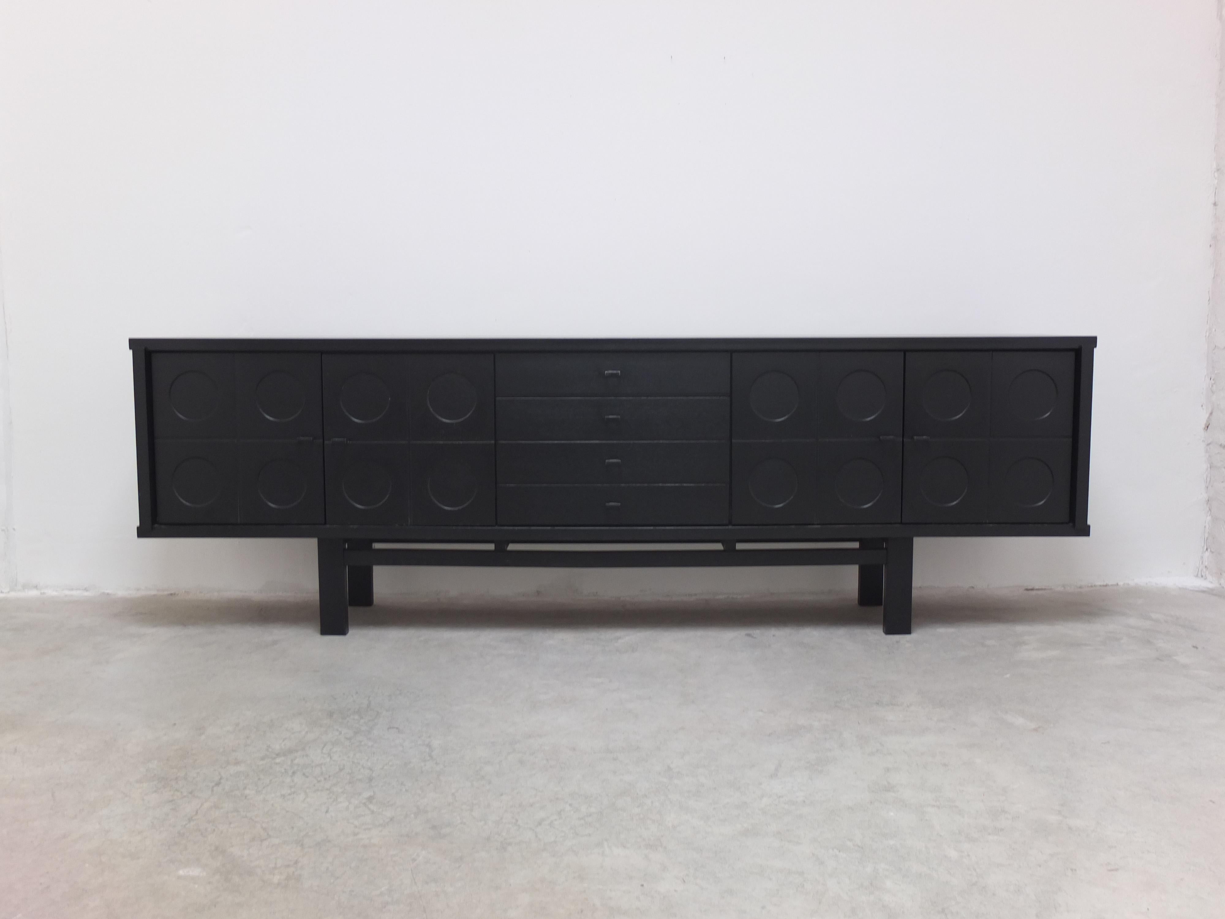 A stunning graphical sideboard in black stained oak produced in Belgium during the 1970s. Often attributed to Belgian manufacturer ‘De Coene’, this sideboard features four graphic door panels and four central drawers. The length of 280cm (!)