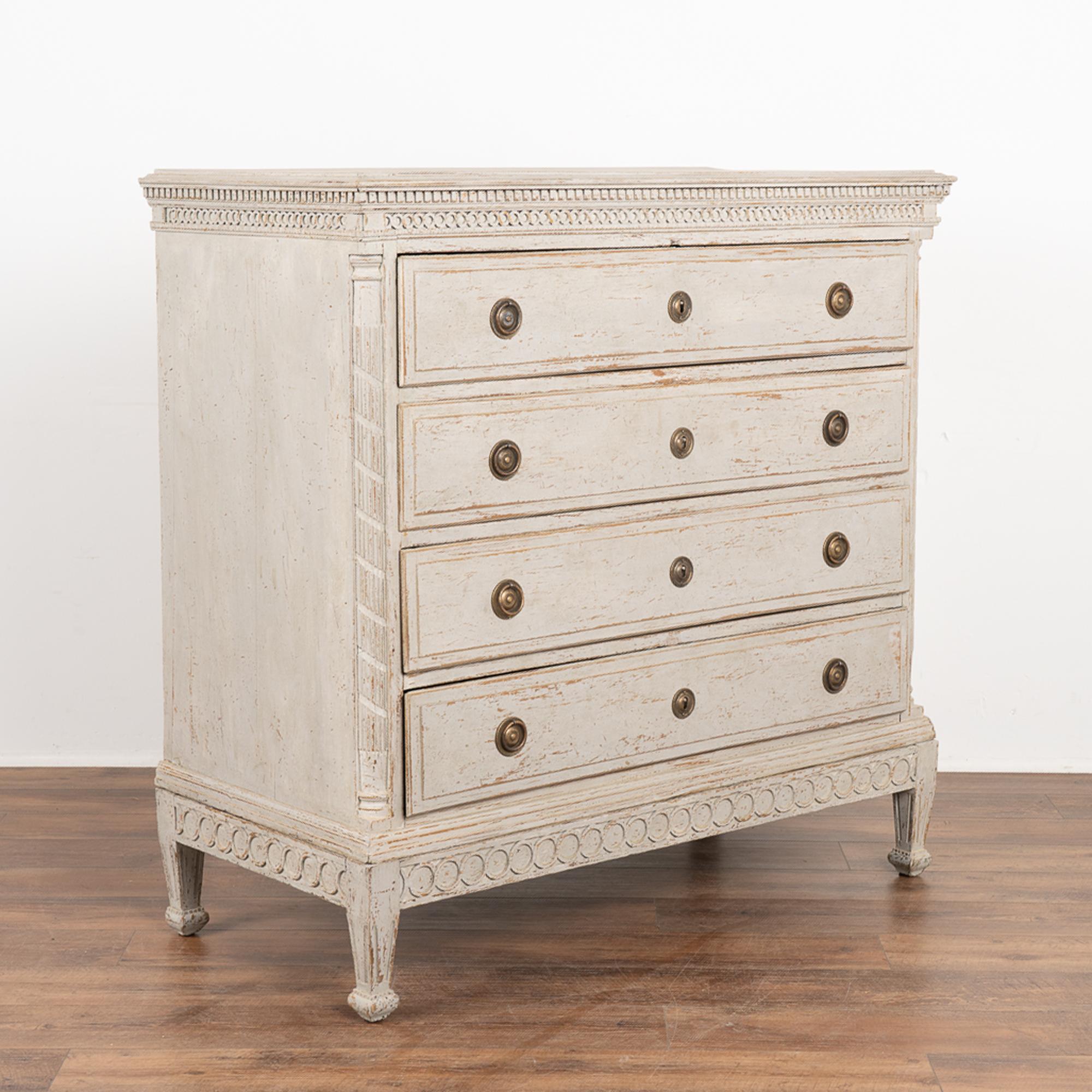 Large pine chest of four drawers with dentil molding and decorative carving along top and skirt. 
The newer, professionally applied soft gray painted layered finish adds a touch of grace that fits the age of this large chest.
Carved details, fluted