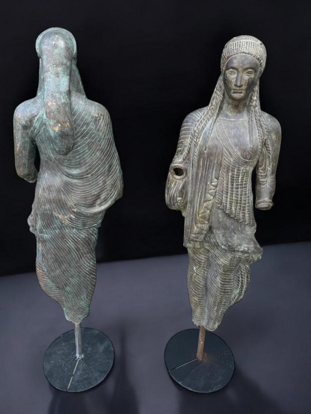 Titolo: Coppia di sculture in bronzo della Kore di Peplos - inizio XX secolo con basi moderne

Panoramica del prodotto: Questa squisita coppia di sculture in bronzo è una fedele riproduzione della Kore di Peplos, uno dei capolavori del periodo