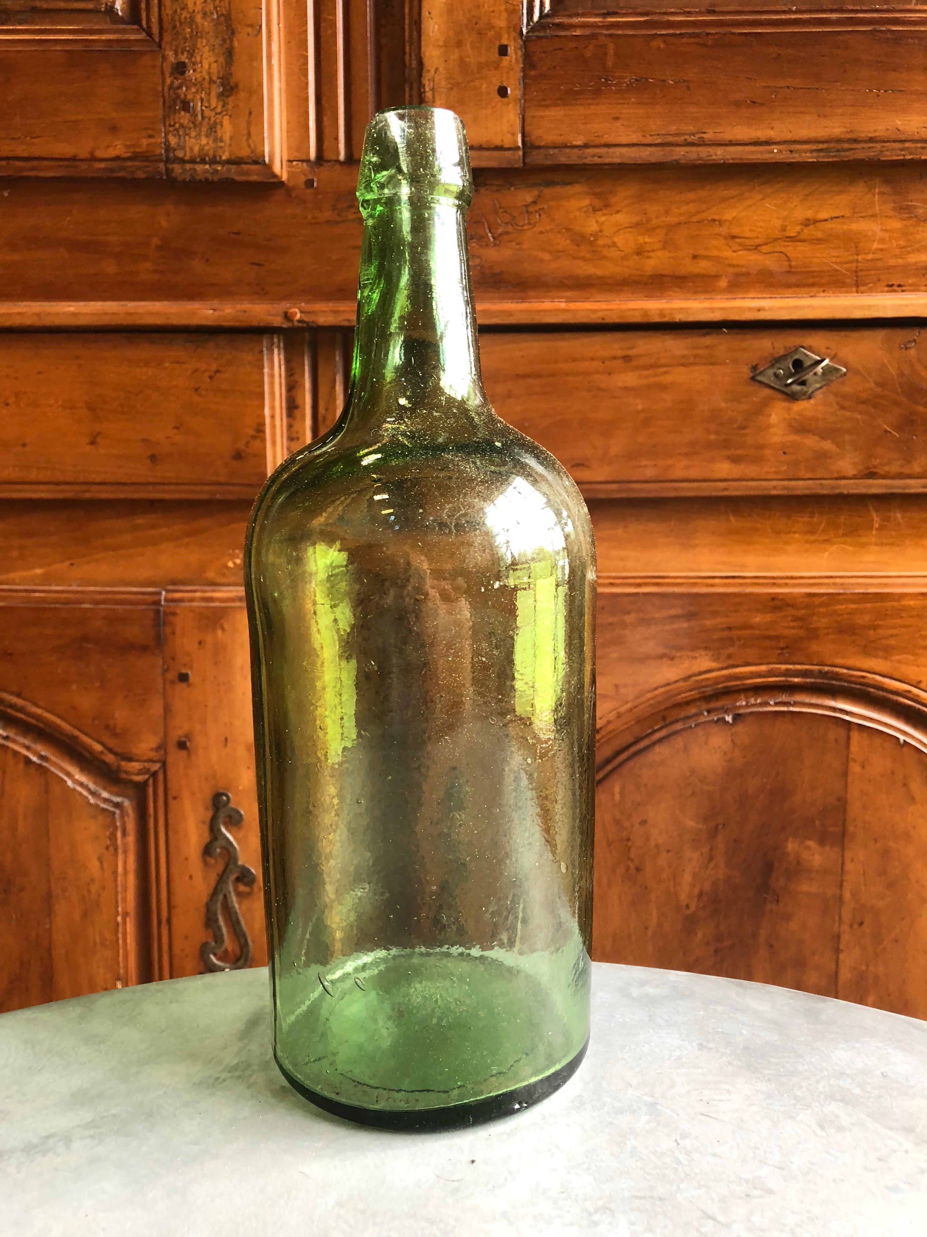A large green glass handblown bottle, probably for whisky, American, circa 1870.