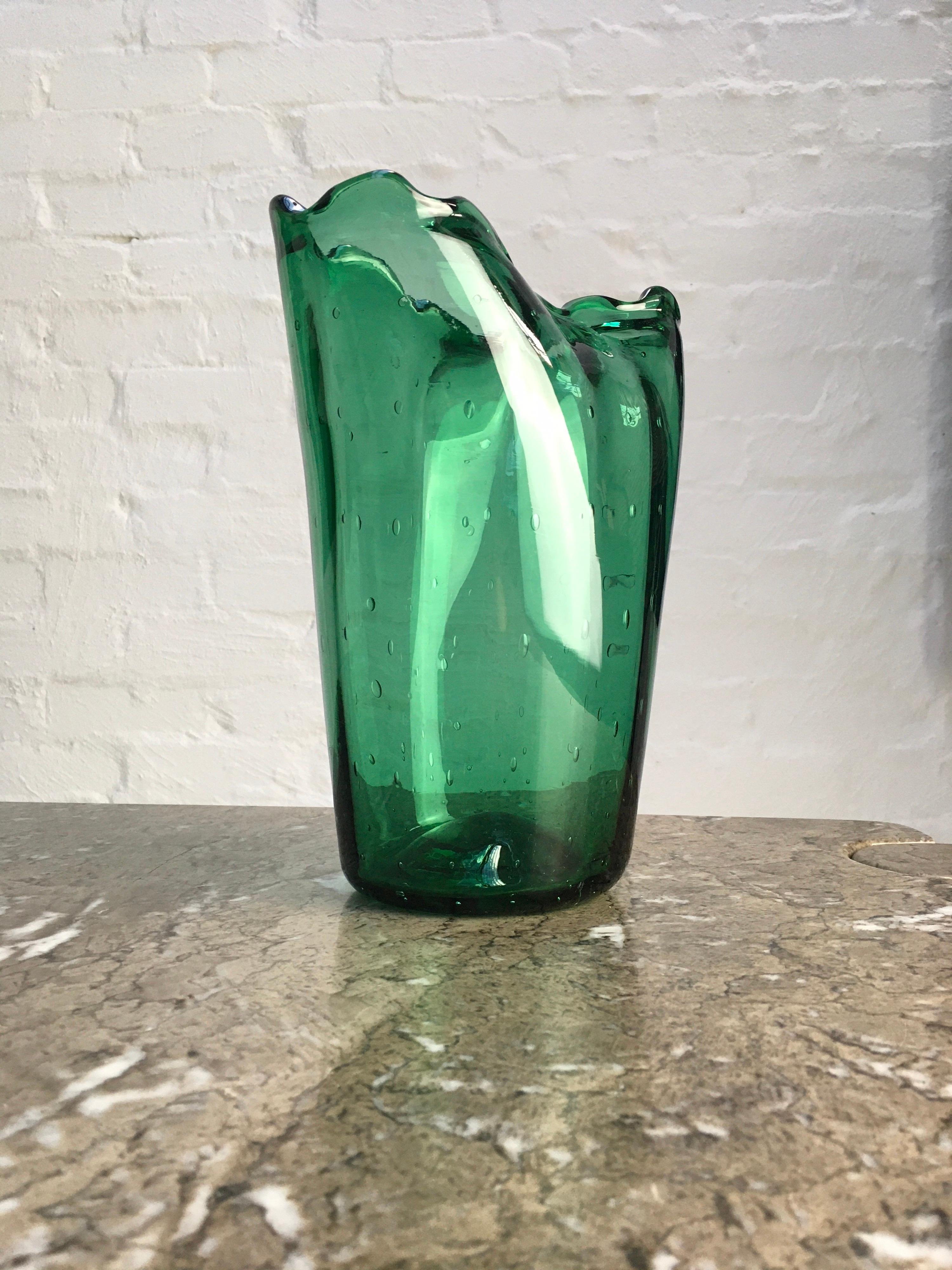 A large vase in a beautiful Bottle Green colour. Wide-set controlled bubbles, a rounded edge to the foot, a ground pontil and undulating lip all indicate the style (if not the work) of Seguso. A very handsome vase. 

Good condition to the visible