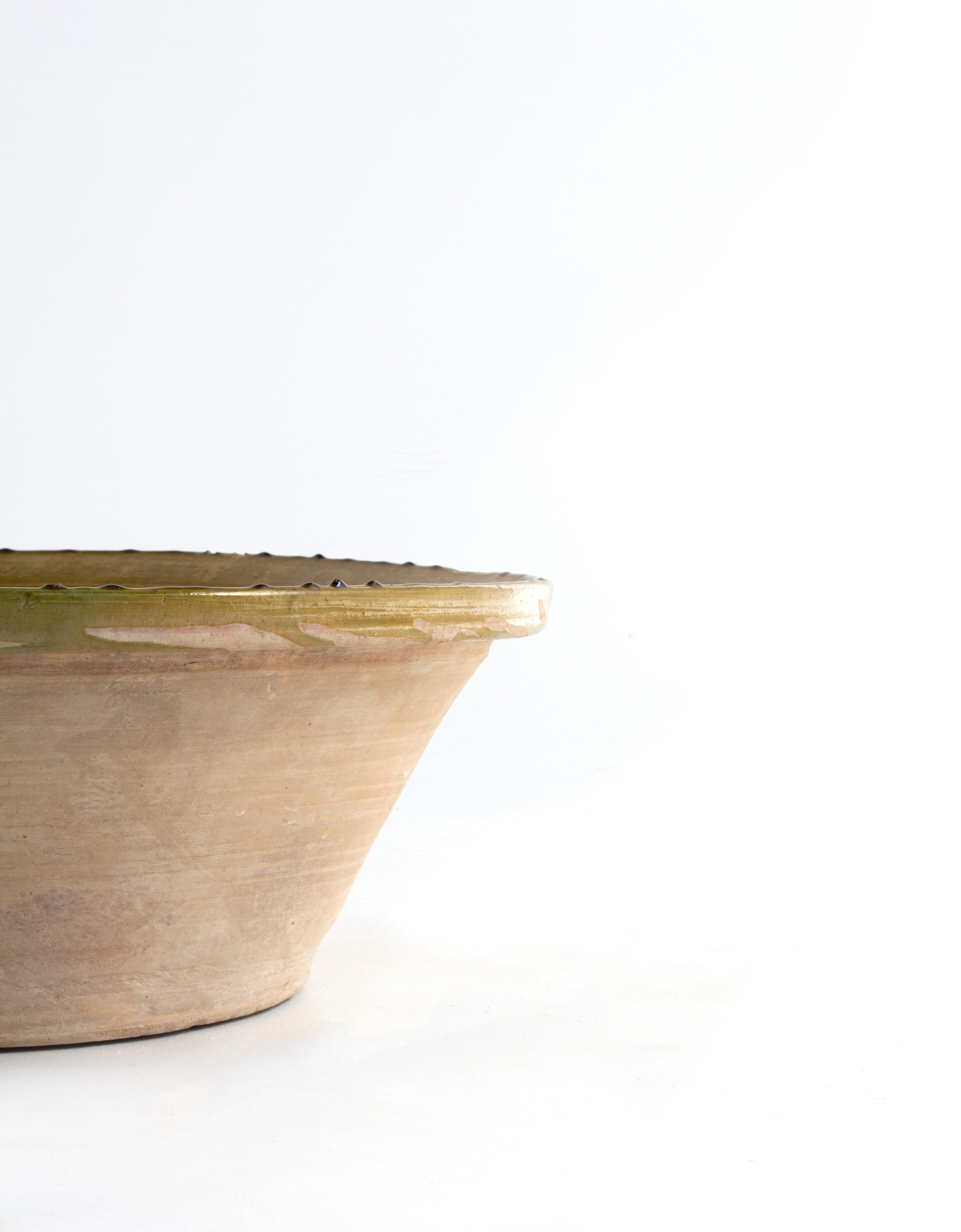 A simple, beautiful, and hand-formed vase that adds a touch of color, global complexity, and modern design. This beautiful green ceramic bowl is the perfect addition for a home that has an organic, contemporary, vintage, and mid-century modern