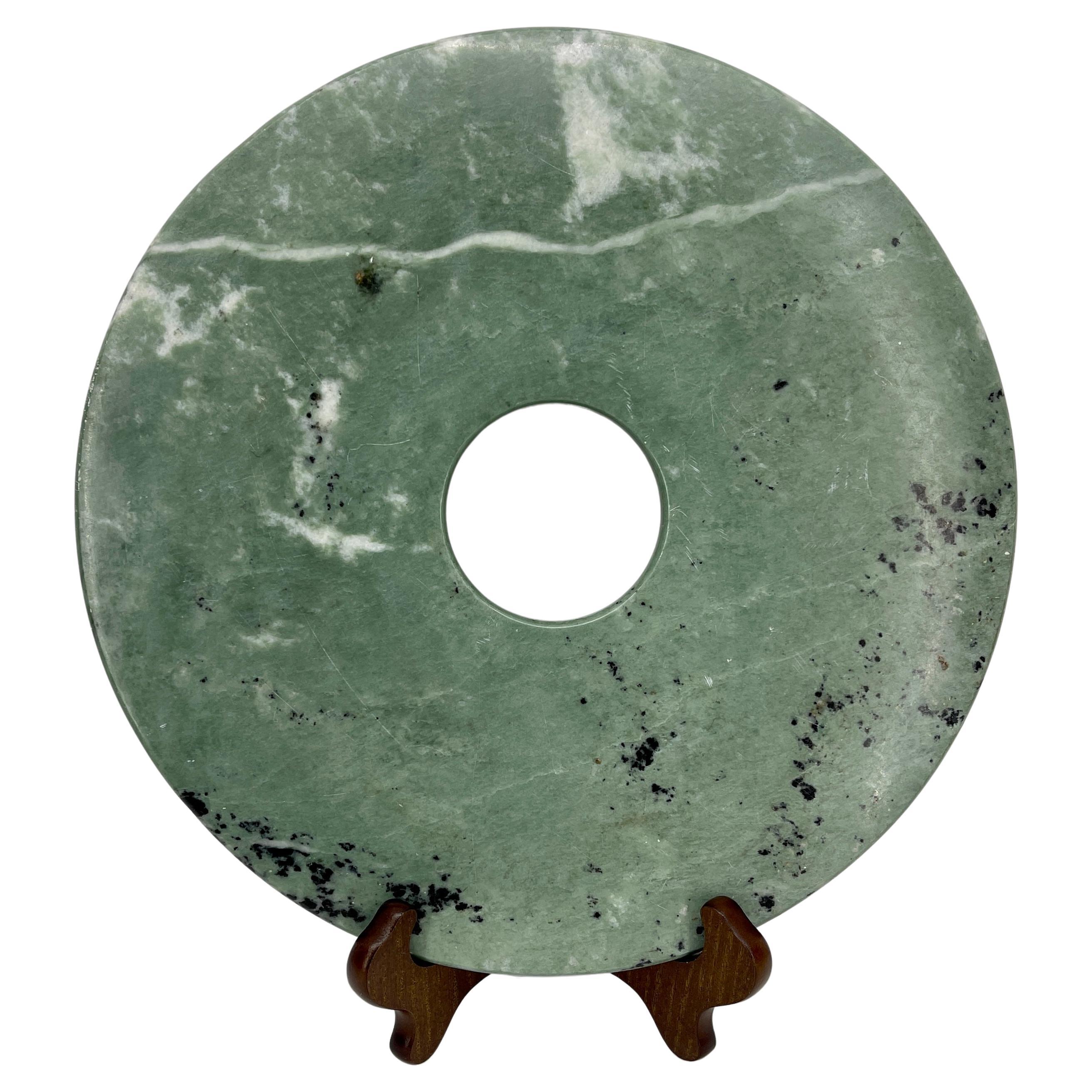 Green Chinese marble money stone table top statue, Mid-Century Modern.
Large green marble with beautiful dark veins is reminiscent of Chinese jade money stone. The rich green stone is polished with center hole having polished edges as well. As a