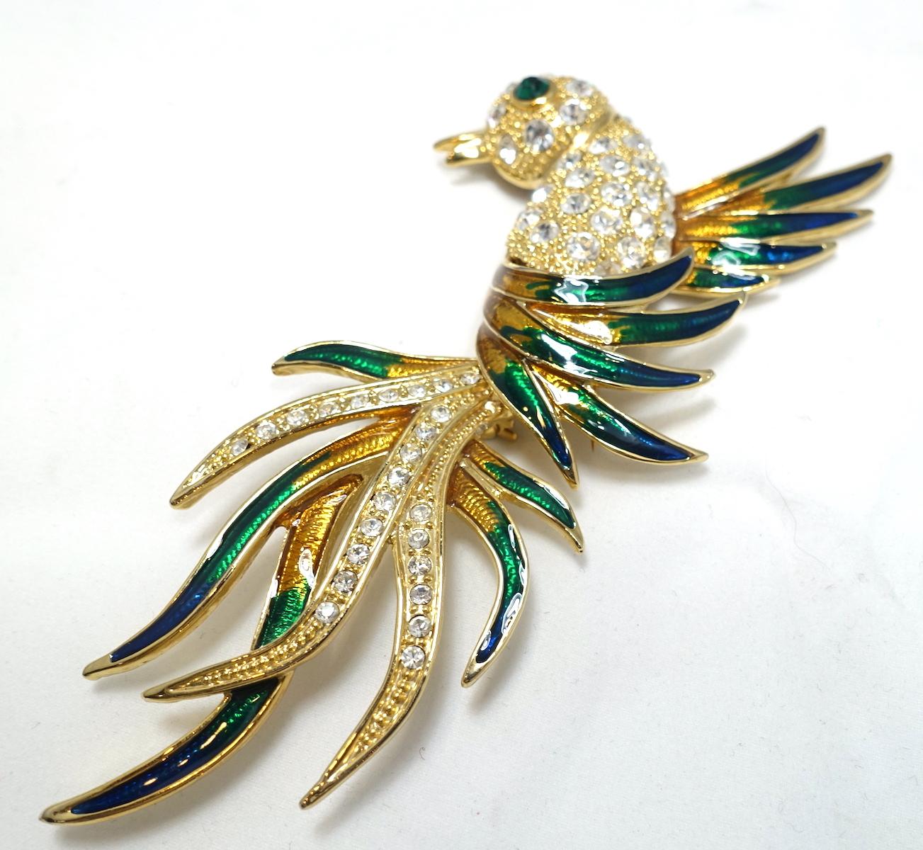 This huge bird brooch has a clear crystal body.  The wings have green and gold enameling in a gold tone setting.  In excellent condition, this brooch measures 5-3/4” x 2-3/4”.
