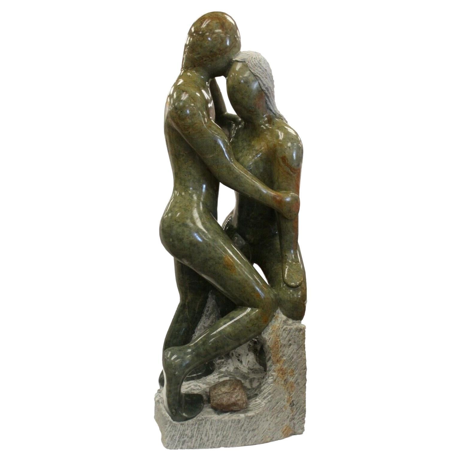Grande sculpture décorative en grès vert représentant deux personnes s'embrassant