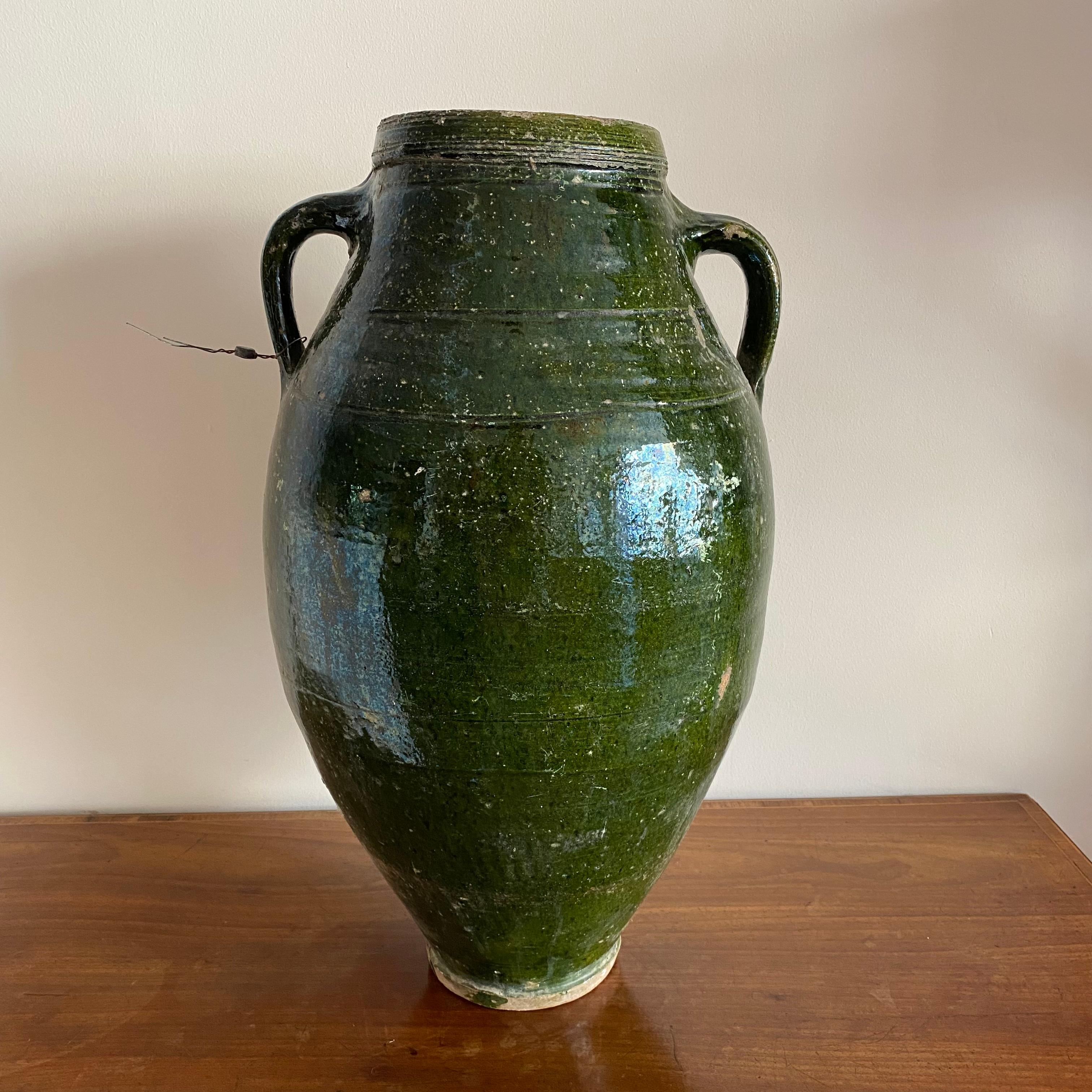 A very large French urn shaped pot with green glaze and 2 handles. Retaining its original lead seal.

Measures: Height: 52cm

Width: 29cm

Depth: 27cm.