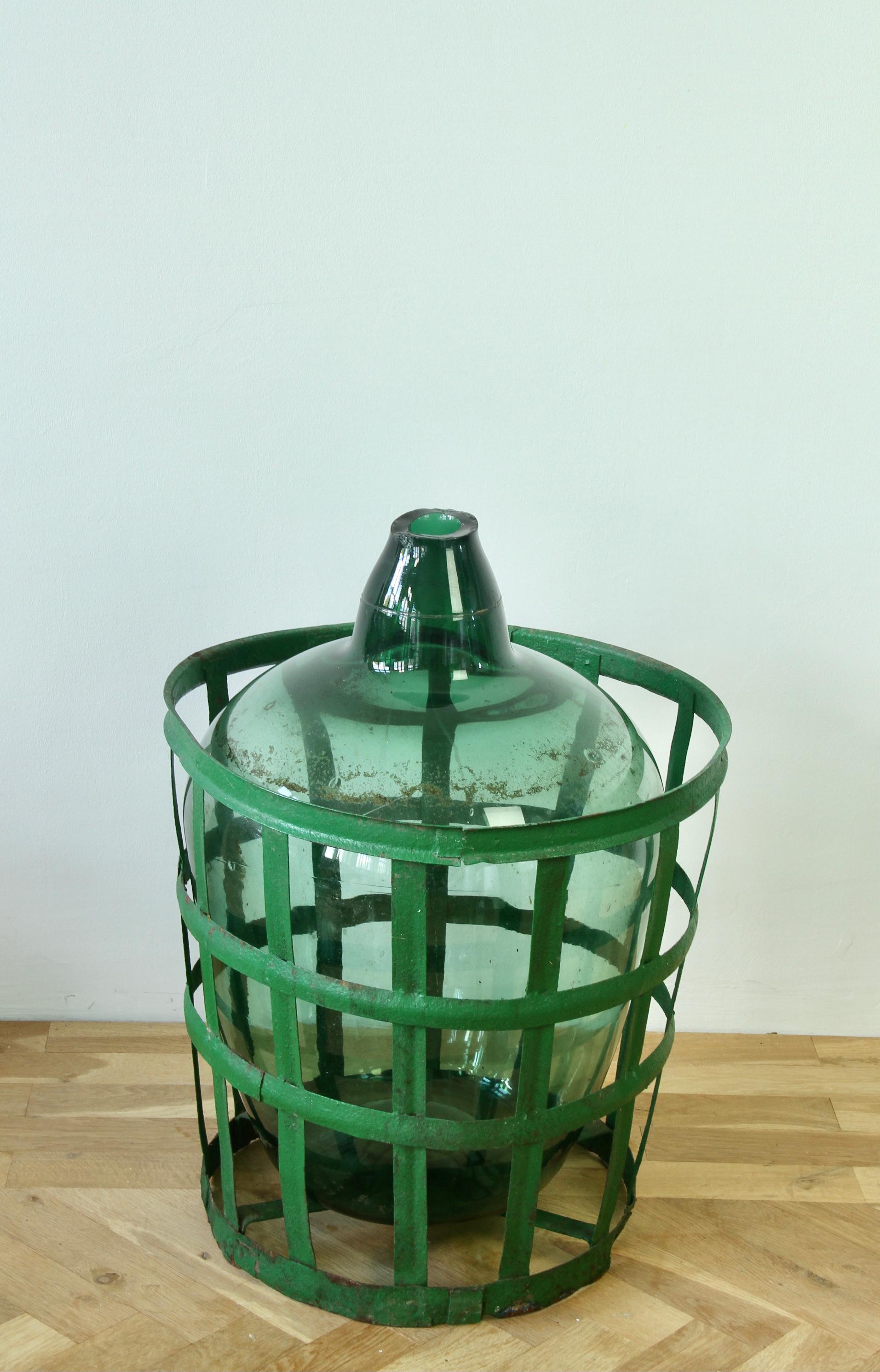 Alta, grande ed enorme damigiana di vino in vetro verde vintage, bottiglia o anfora con il cesto originale in ferro battuto e metallo dipinto di verde - un reperto piuttosto raro. Questo modello è stato soffiato a bocca e realizzato a mano in