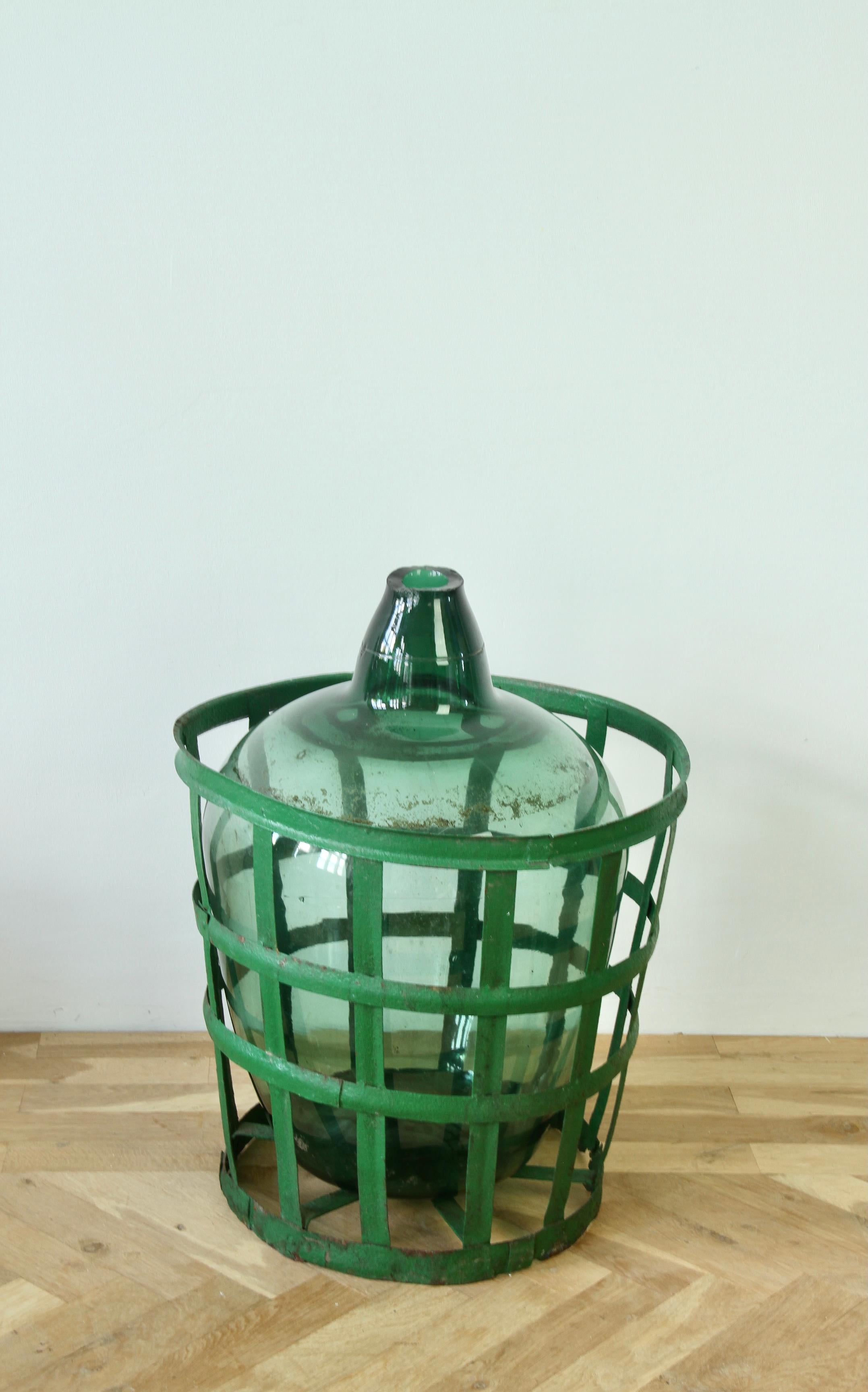 Ungherese Grande damigiana, anfora o vaso ungherese in vetro verde con cesto originale in ferro in vendita