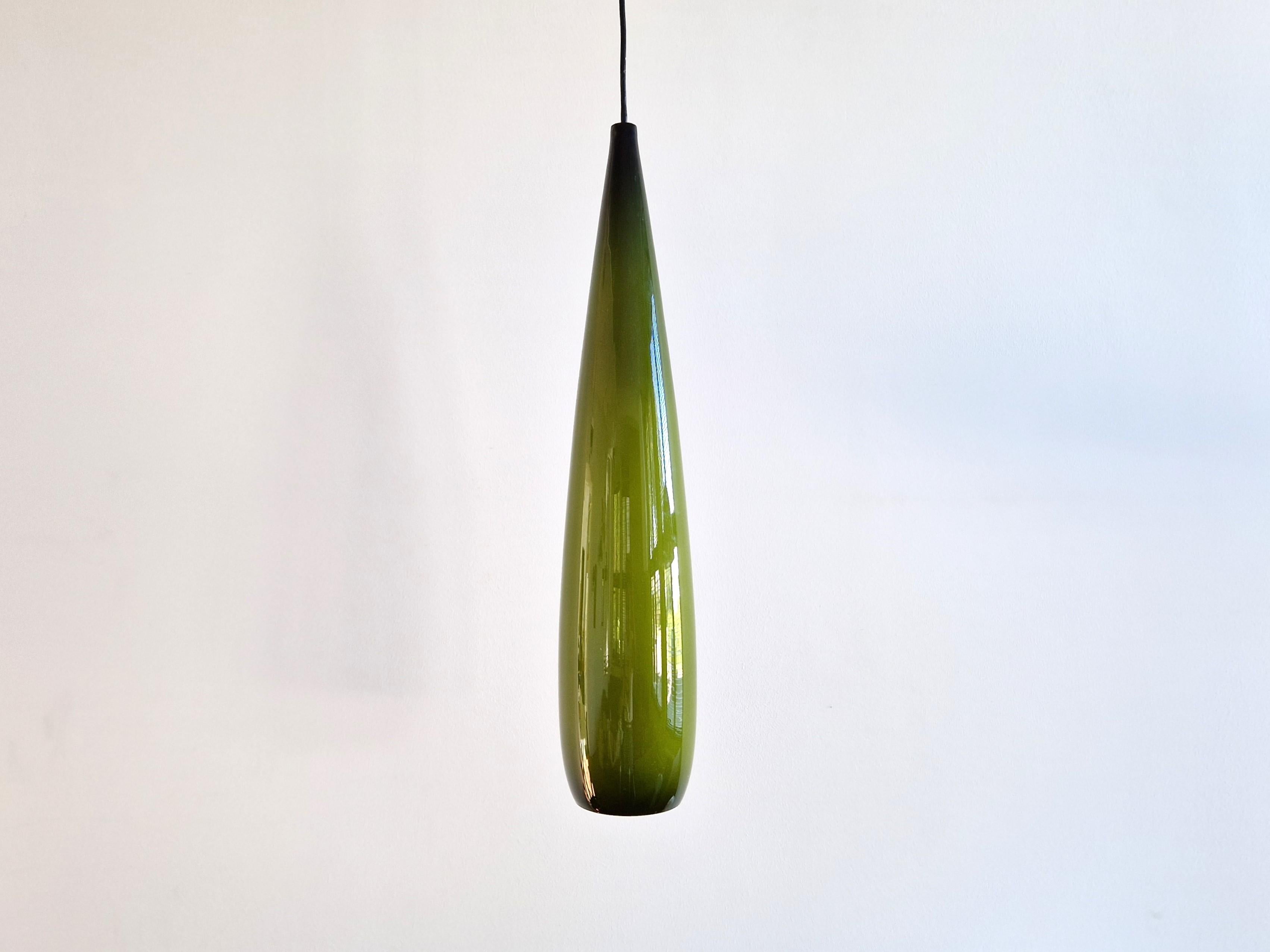 This fantastic pendant lamp was designed for Kastrup Holmegaard in Denmark. It is made out of green colored glass with a white opaline inside that gives a beautiful warm and soft light. The lamp is in a very good condition, with some small signs of