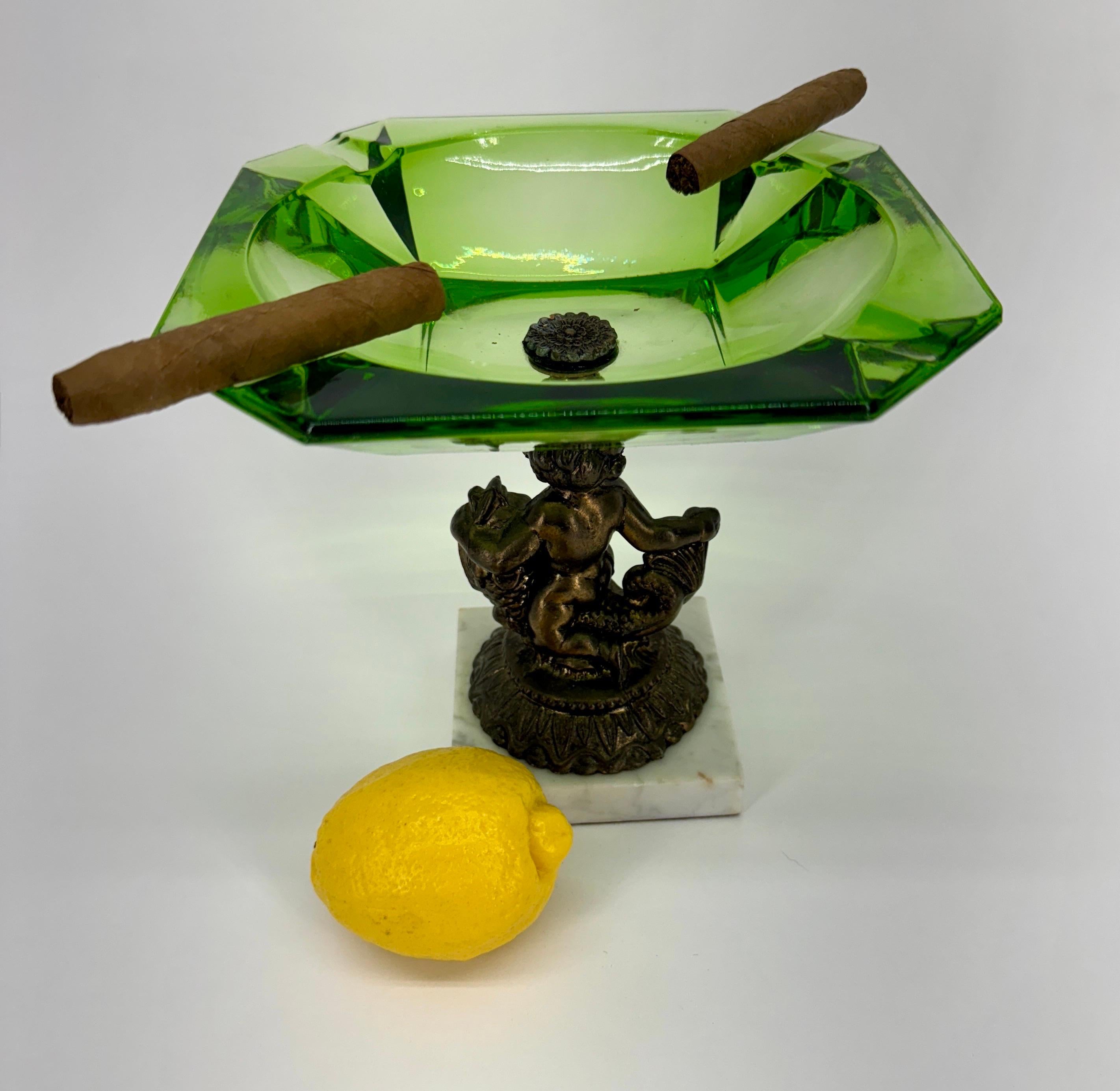 Emerald Green Glass Cigar or Cigarette Ashtray with Bronze Putti Sculpture

This large green glass ceramic ashtray with a cheerful bronze cherub is particular suited for large cigars. This ashtray can also be used as a unique trinket dish or jewelry