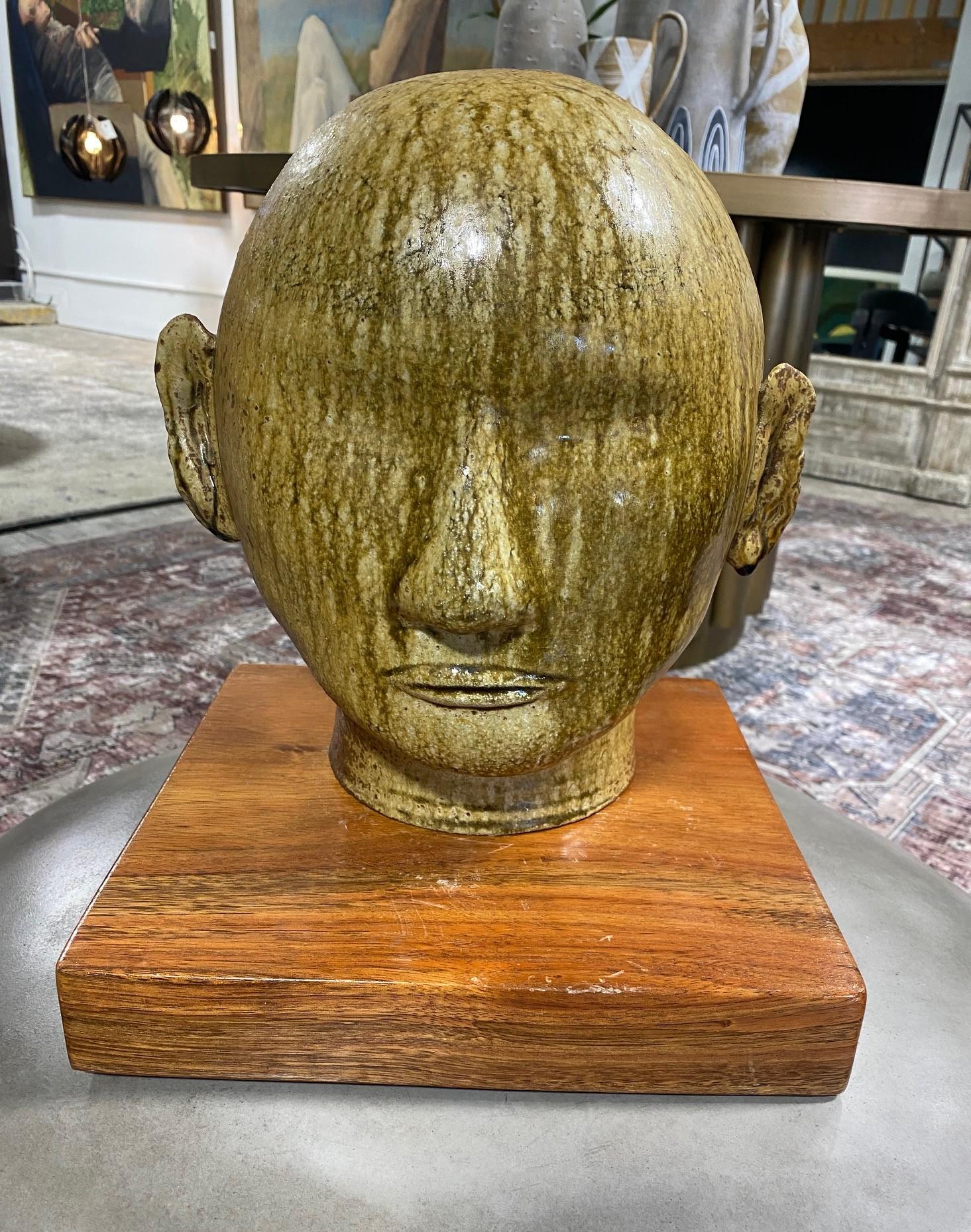 A truly wonderful, one of a kind, unique artisan Buddha head sculpture beautifully drip glazed with Fall shades of green, brown and yellow colours. The Buddha's eyes appear closed in serene meditation. 

This piece caught our eye straight away.