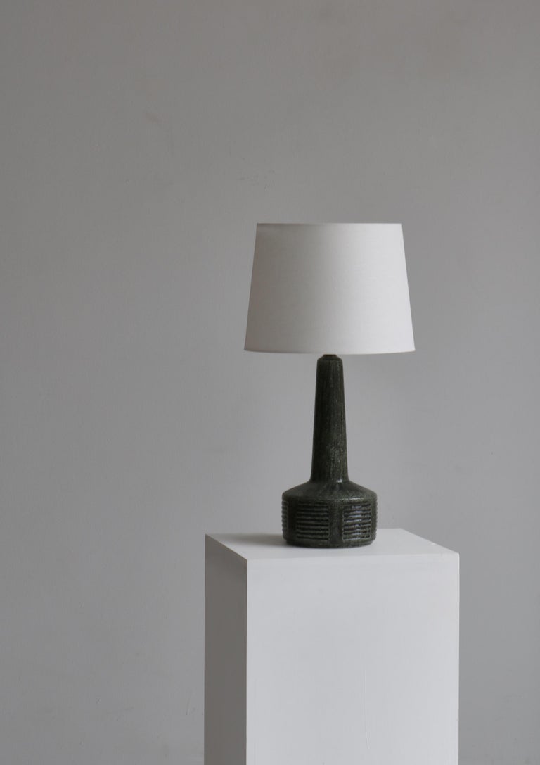 Beautiful and unique large chamotte stoneware table lamp in dark green glazing by Per Linneman-Schmidt for Palshus, Denmark. Made in the 1960s. Marked underneath by maker. New white flax linen shade.

Per Linnemann-Schmidt trained the Royal Danish