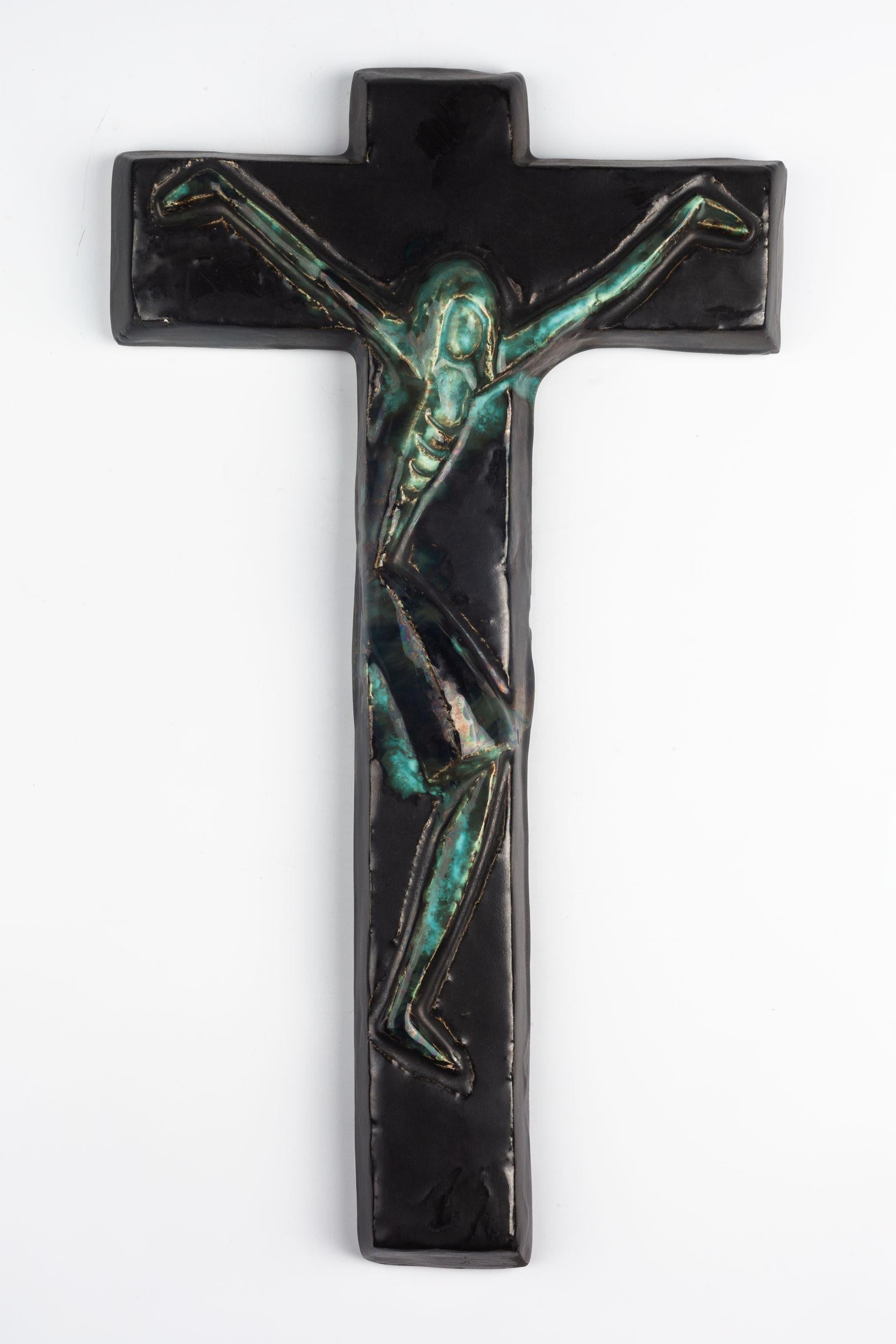 Large sixteen-inch tall ceramic crucifix, handmade in Europe in the 1960s. Colorfully painted in deep and light blue and green tones with an abstracted, angular Christ figure. A one-of-a-kind, handcrafted piece that is part of a large collection of