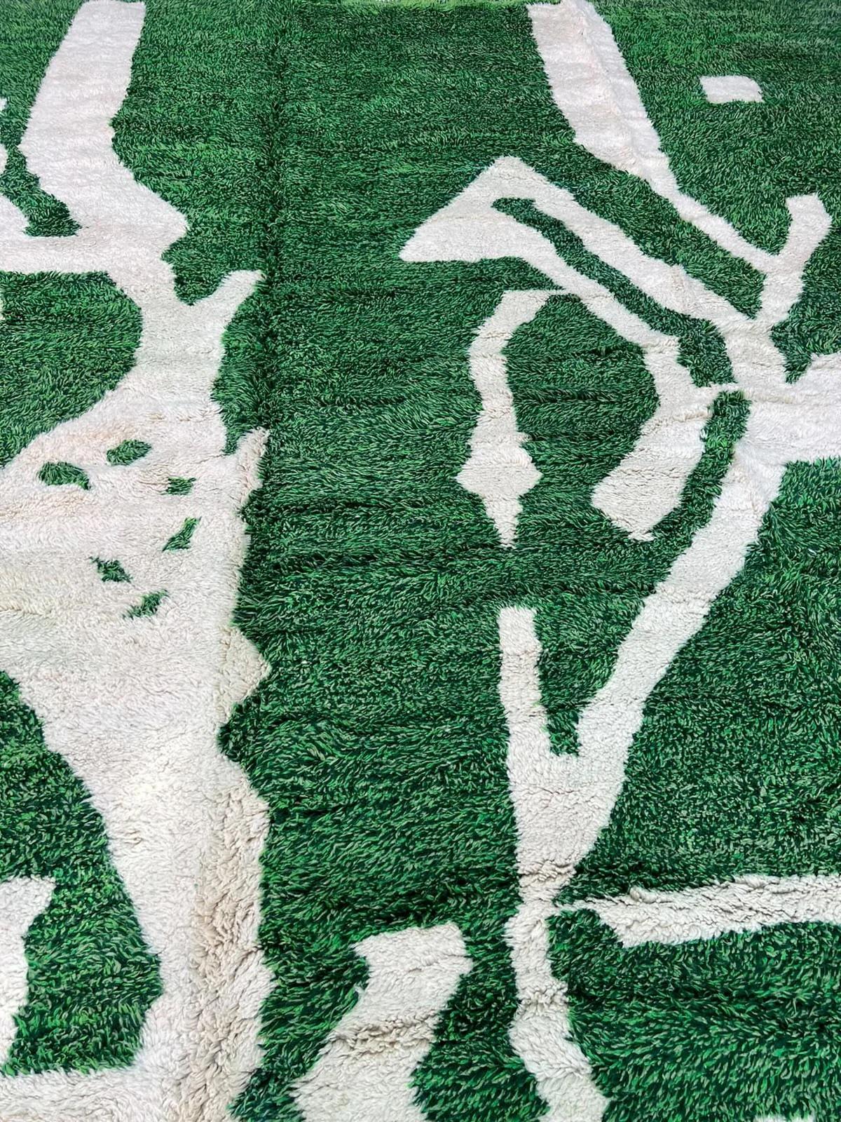 Ce grand tapis marocain vert tissé à la main a été fabriqué par des artisans qualifiés dans les montagnes de l'Atlas en utilisant la laine M'Rirt de la plus haute qualité. Il est impressionnant tant par sa taille que par son design, et constitue la