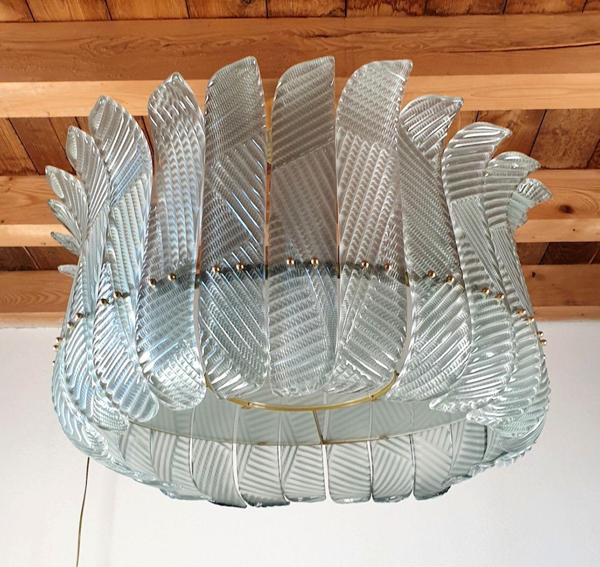 Large Mid Century Modern Murano glass Drum chandelier, in the manner of Vistosi. Italy 1980s
The Murano vintage chandelier has a brass canopy but is almost a flush mount light: remains very close to the ceiling.
It's made of light green textured