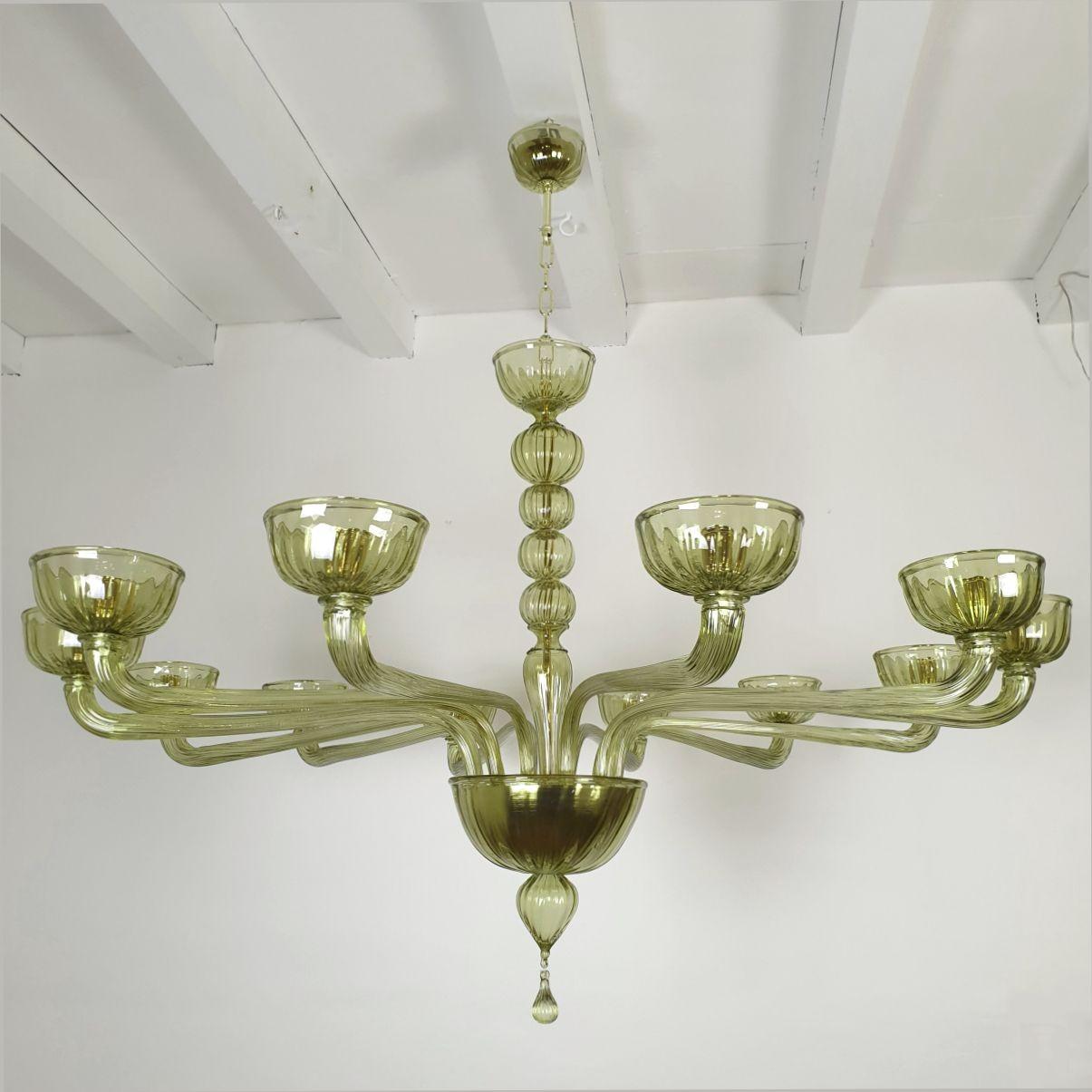 Extra large green hand blow Murano glass chandelier, attributed to Venini, Italy 1980s.
The neoclassical style chandelier has gold plated mounts.
The Murano glass color is a light olive green.
The large Mid Century Modern chandelier has twelve