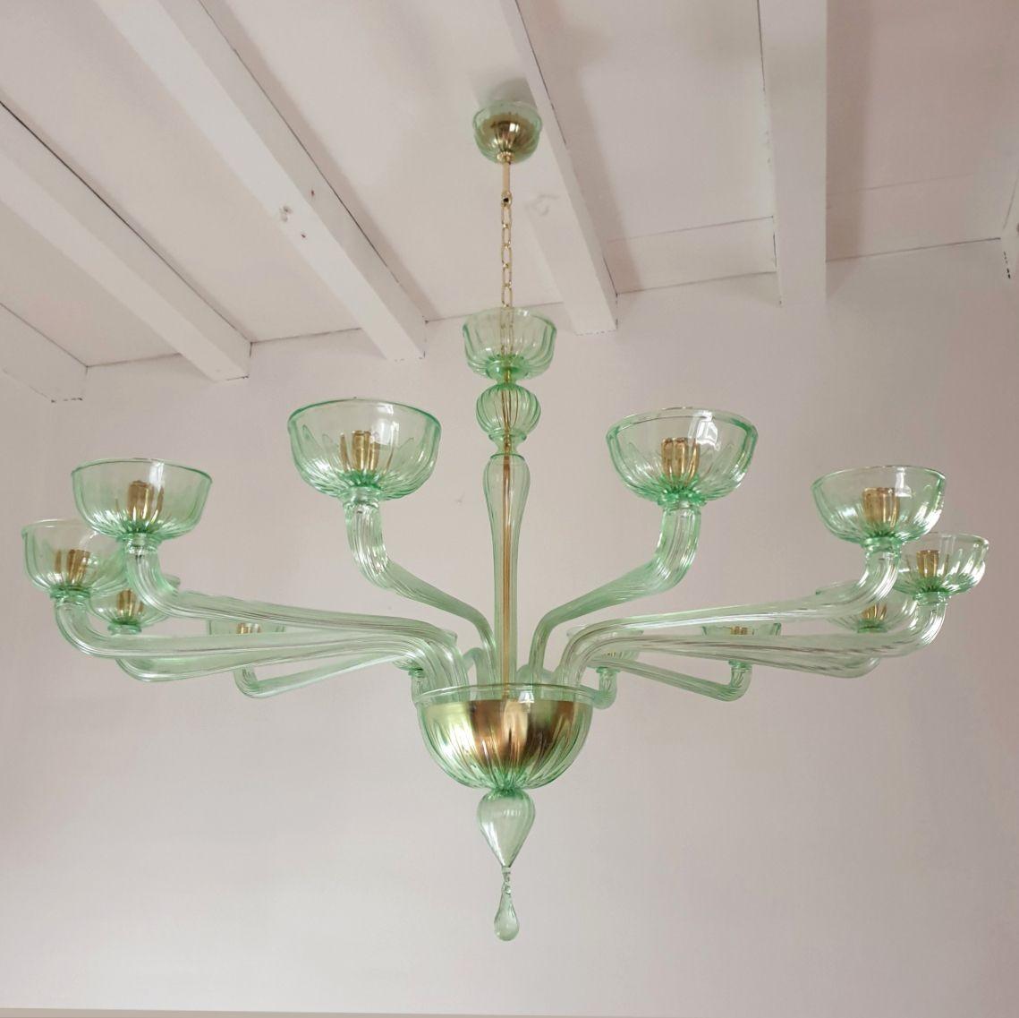 Very large Murano glass Mid-Century Modern chandelier, attributed to Venini, Italy 1970s.
The hand blown Murano glass chandelier is made in a light green color with gold plated mounts.
The vintage chandelier has a neoclassical style.
It has twelve