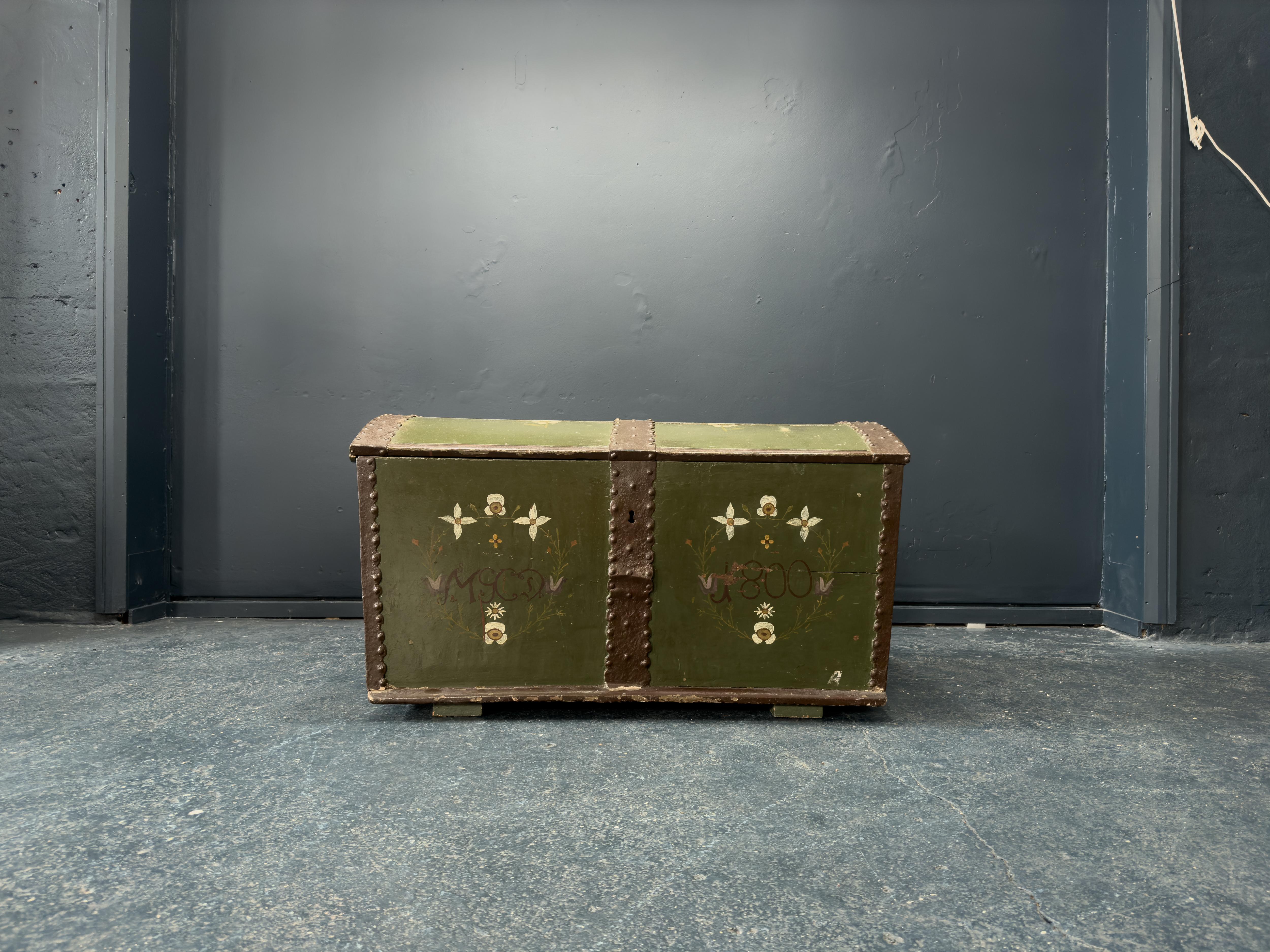 This gorgeous Danish folk cabinet is a spectacular piece with incredible character. Painted in a stunning forest green with a delicate white and purple floral design, this chest is a truly beautiful piece. With original metal hard wear and