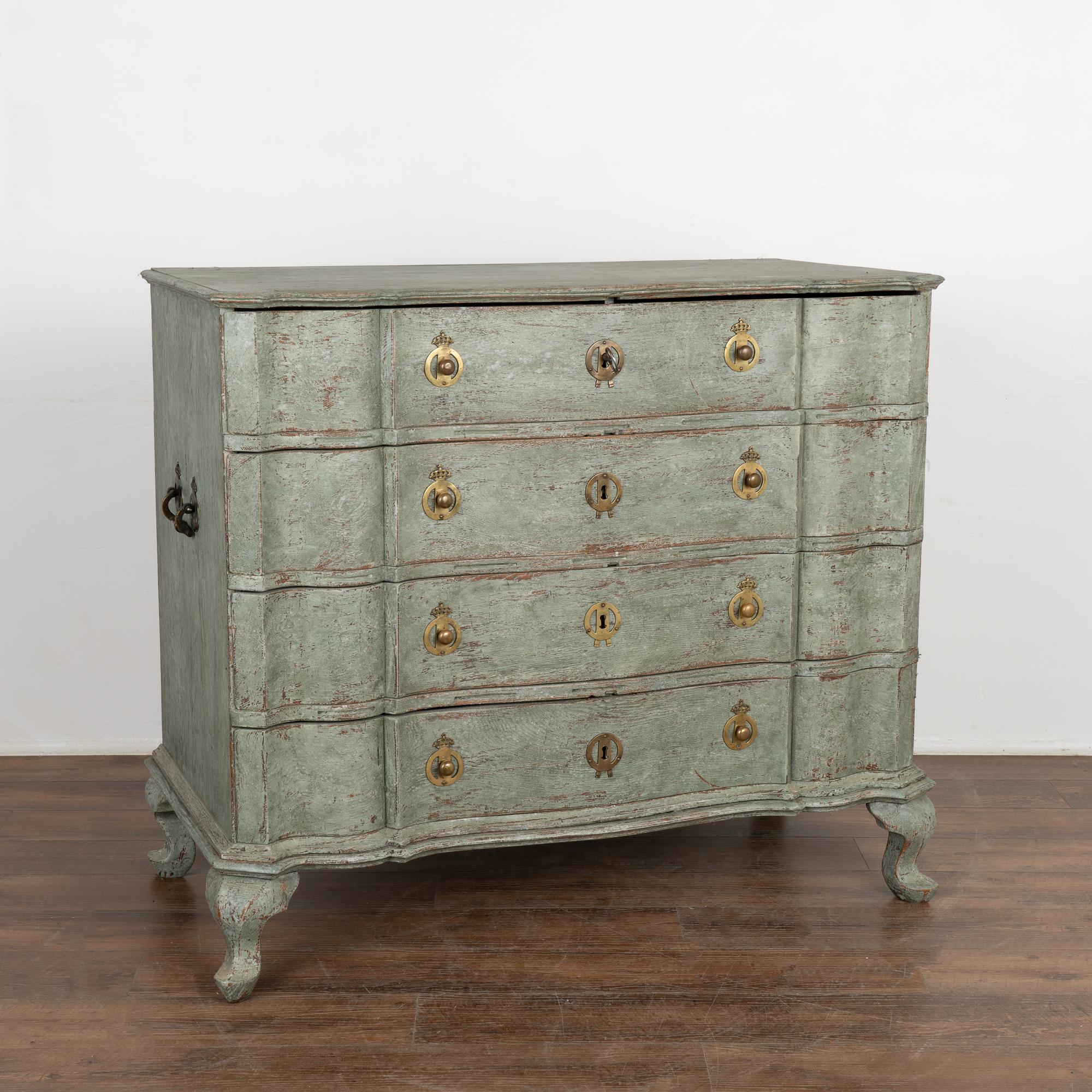 This large antique rococo oak chest of drawers features a serpentine front, handsome brass hardware pulls and rests on cabriolet feet.
It has been given an exceptional new professional seafoam green layered painted finish and has been lightly