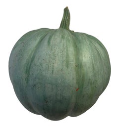 Large green patinated pumpkin in wood